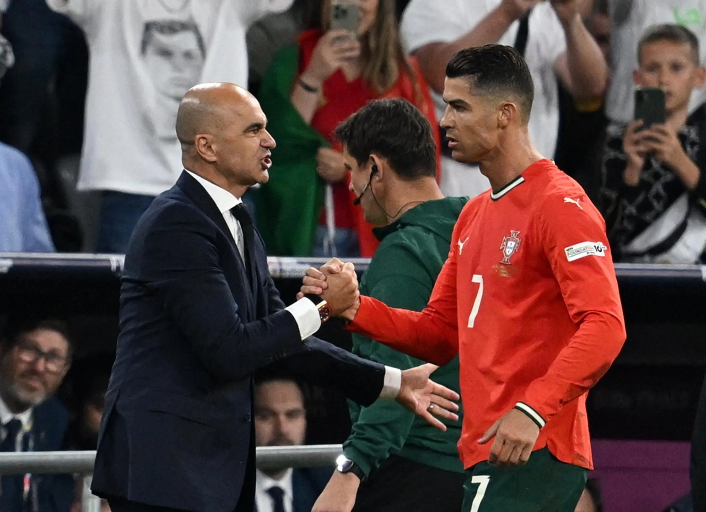 Portugal's Cristiano Ronaldo shakes hands with Portugal coach Roberto Martinez after being substituted.