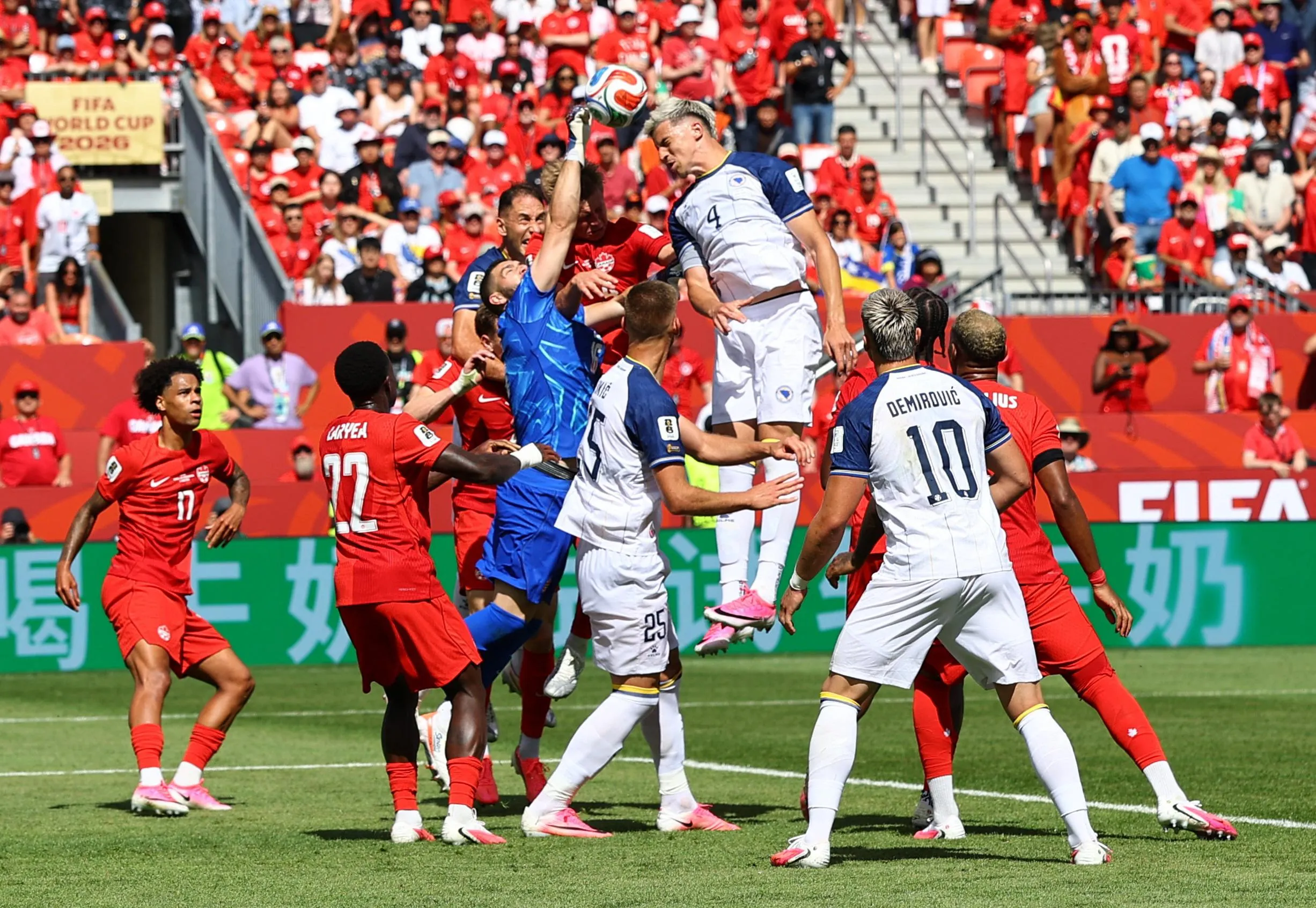 Bosnia and Herzegovina’s Tarik Muharemovic goes up for a header with Canada’s keeper Maxime Crepeau.