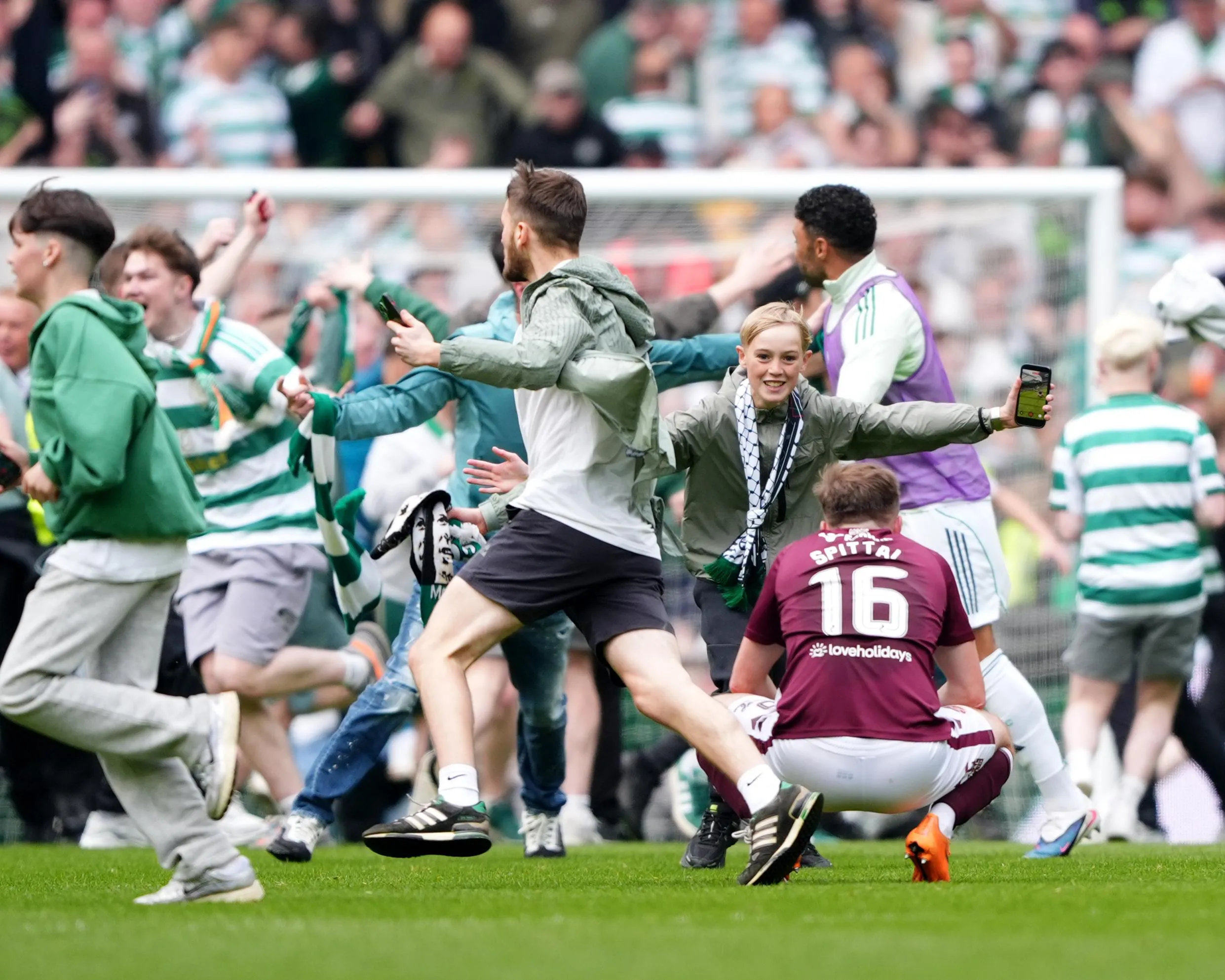 Celtic fans run on to the pitch after their team went 3-1 up against Hearts in the title-deciding game.