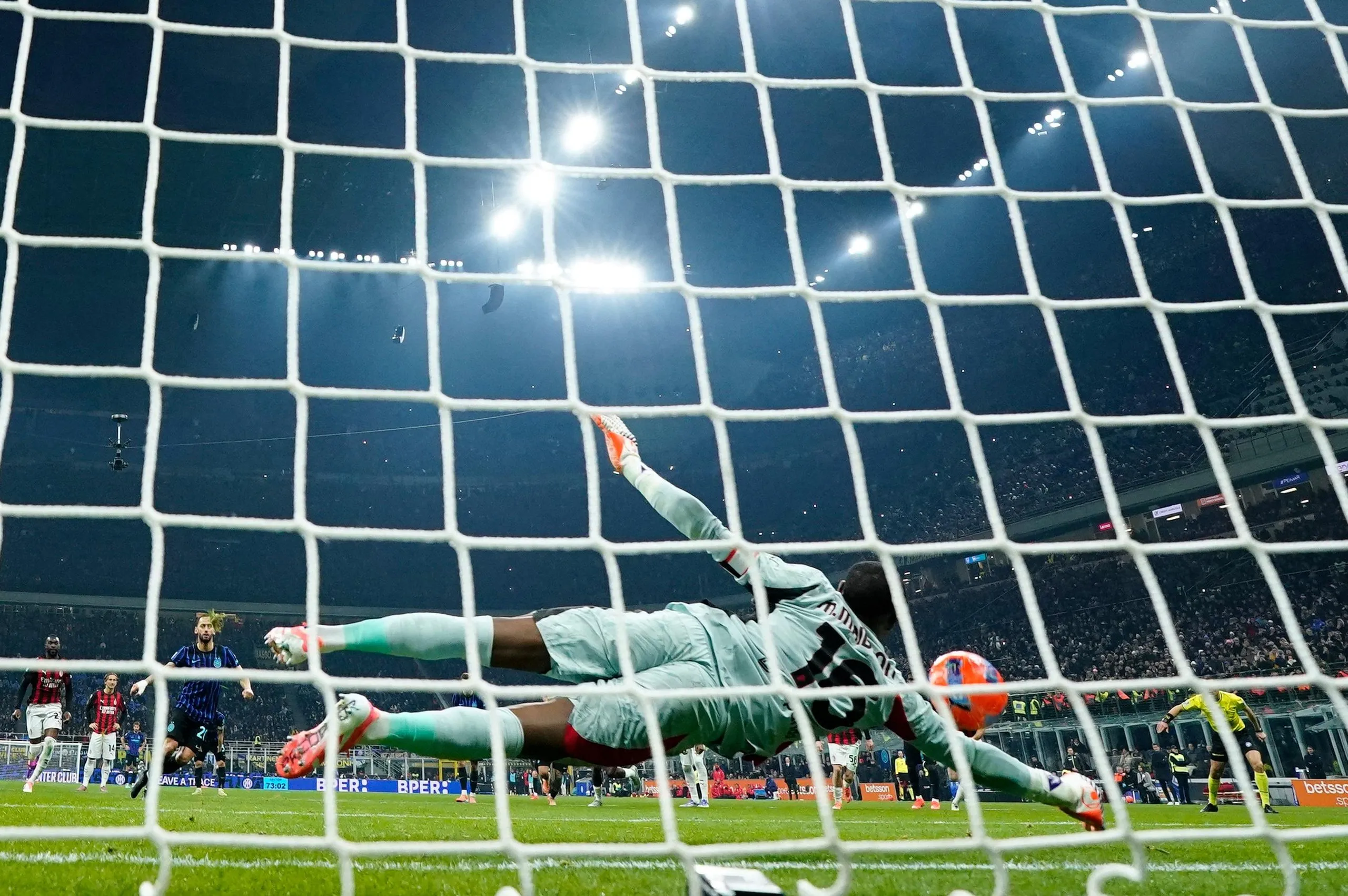 Mike Maignan saves a penalty from Inter Milan’s Hakan Calhanoglu
