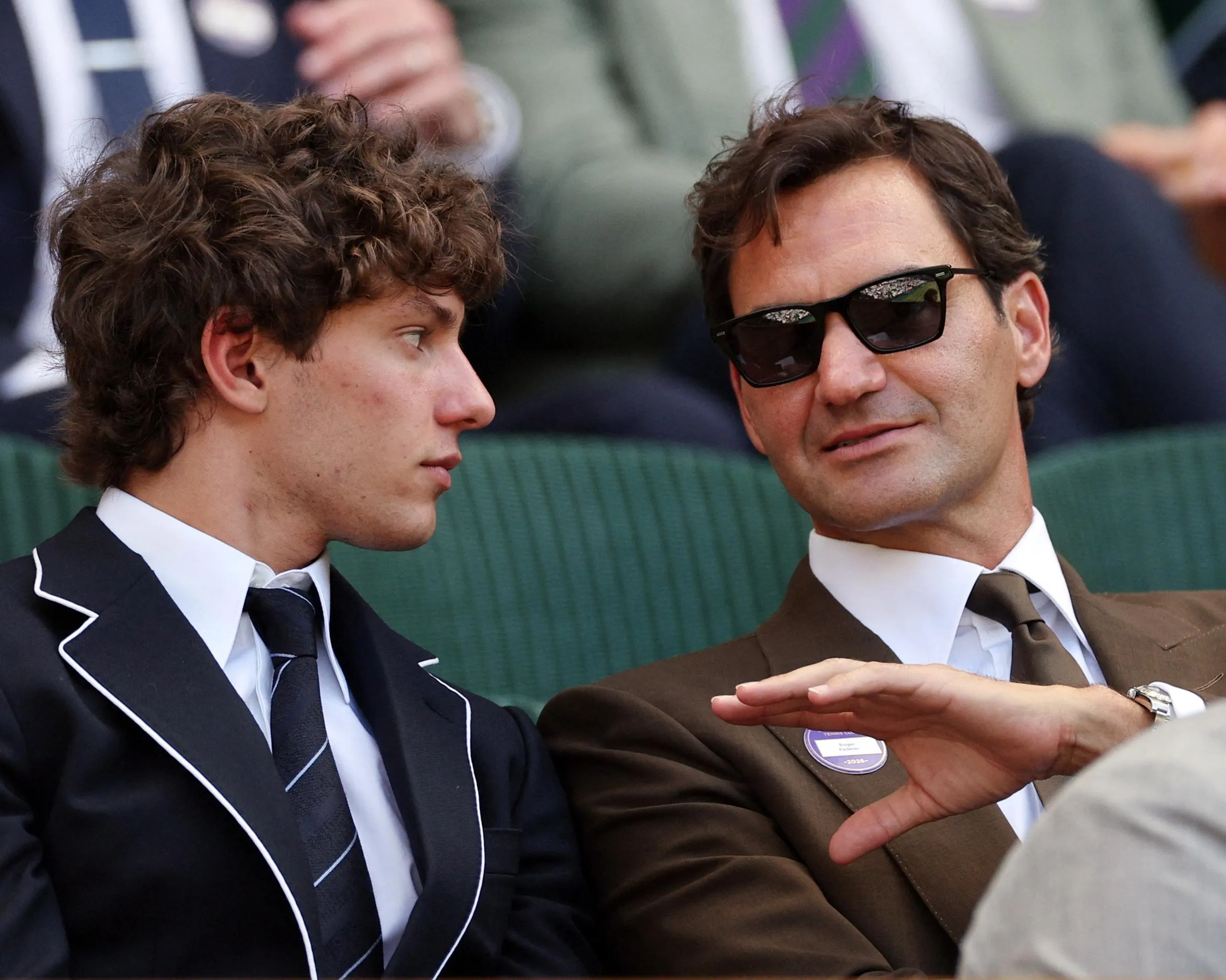 The Formula One driver Kimi Antonelli (left) listens intently while in conversation with the tennis great Roger Federer (right) as they sit next to each other in the Royal Box at Wimbledon.