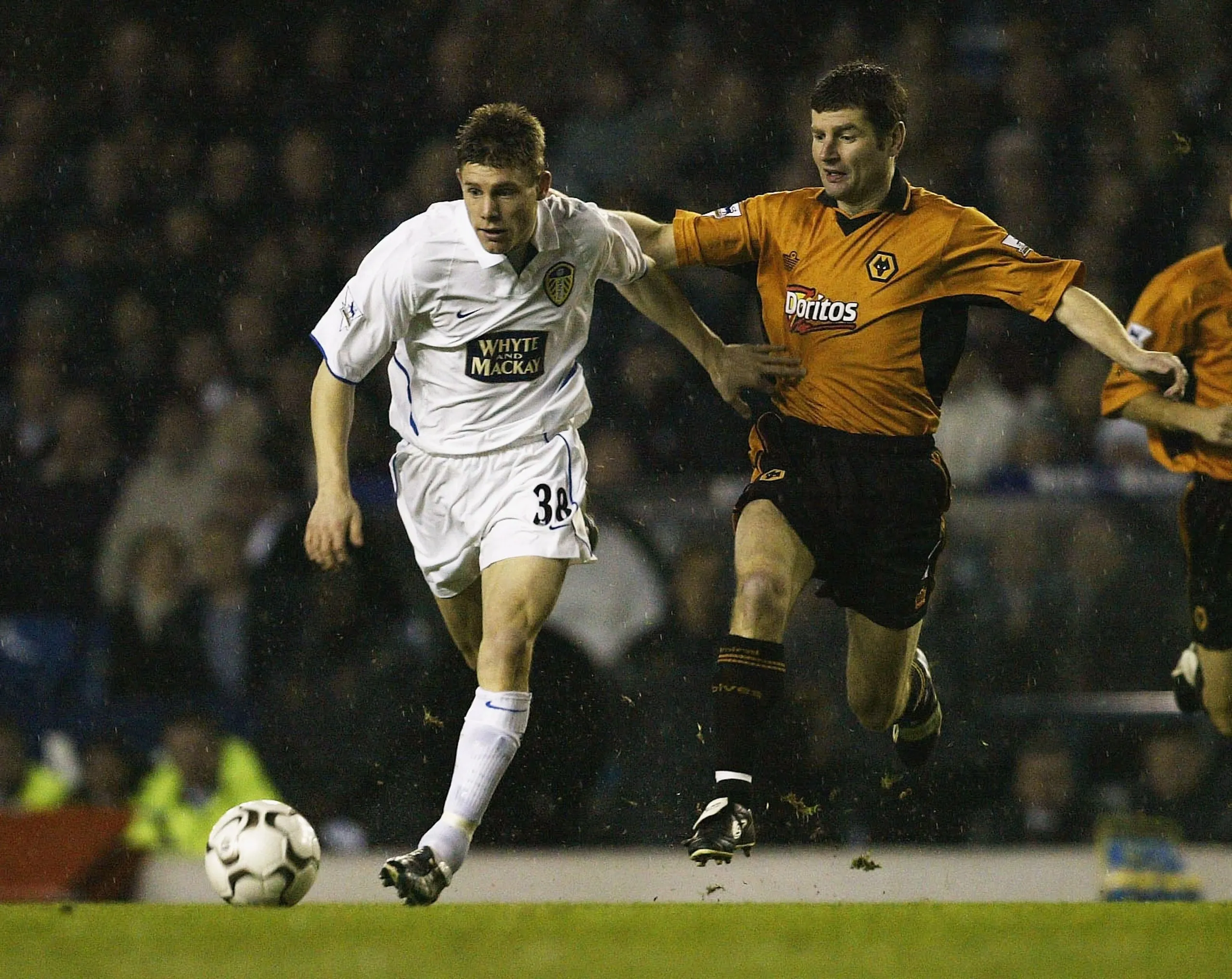 James Milner (left) of Leeds in a white kit clashes with Denis Irwin of Wolves in 2004