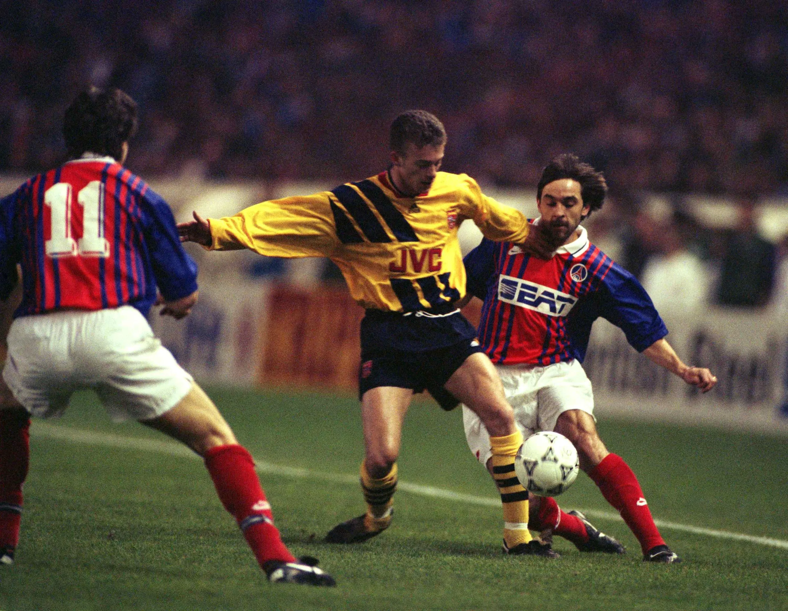 John Jensen fights for the ball with PSG’s Patrick Colleter.