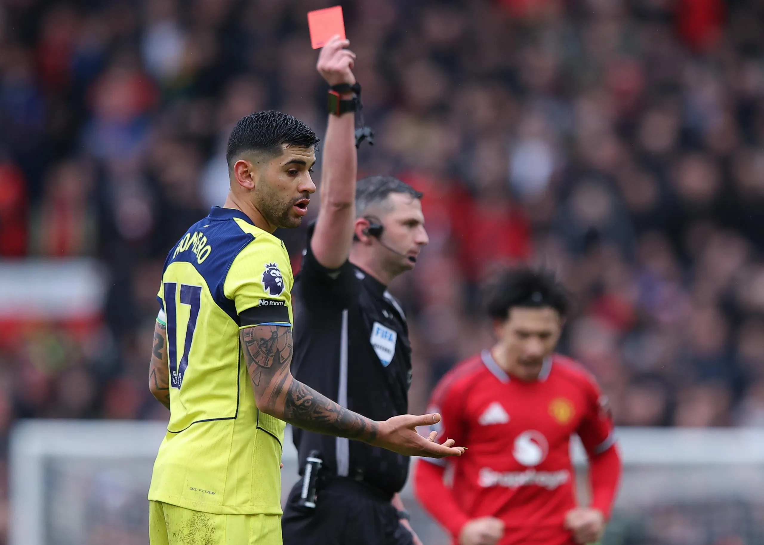 Cristian Romero is shown a red card by the referee as Lisandro Martínez celebrates