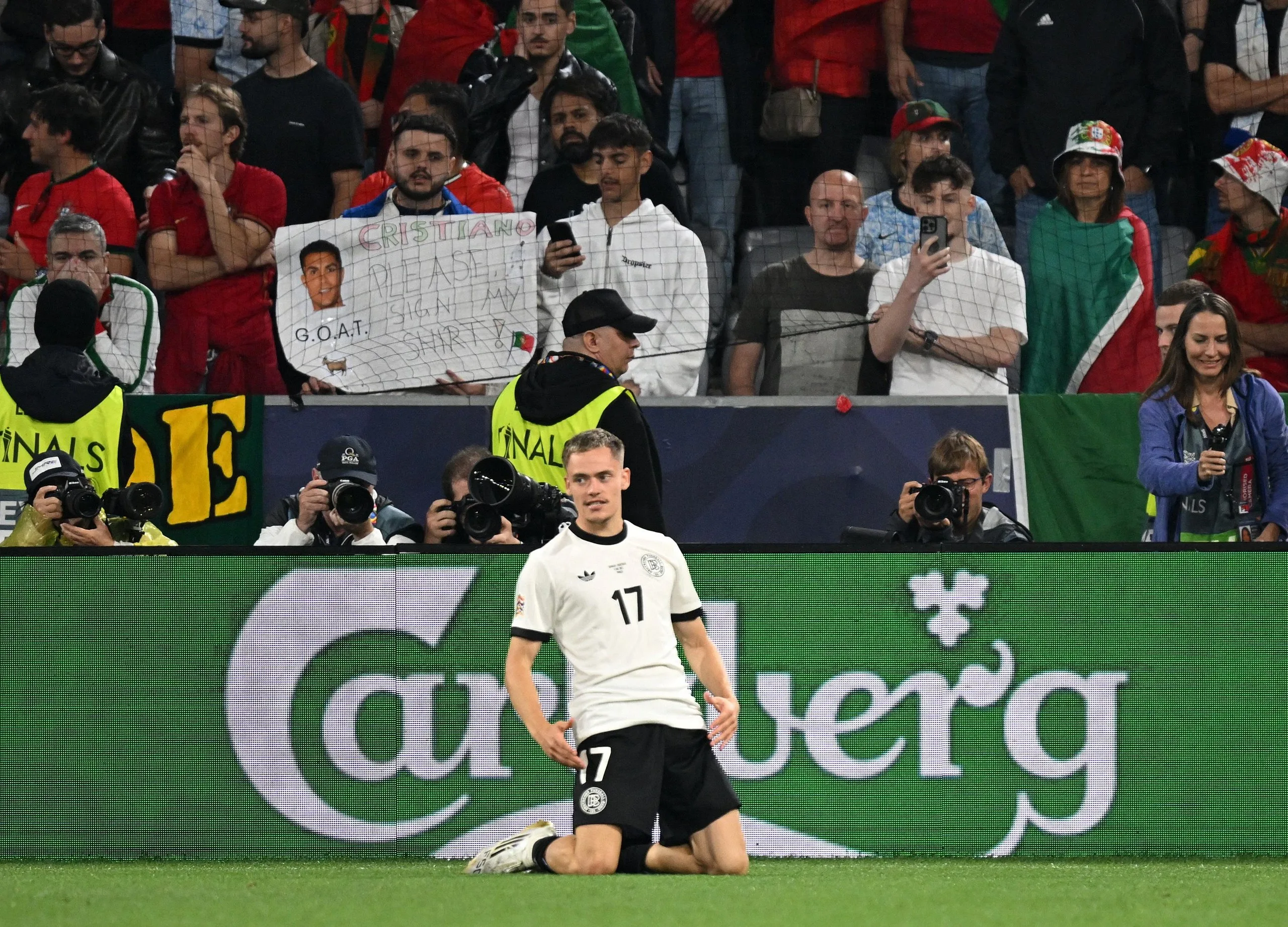 Germany’s Florian Wirtz celebrates scoring their first goal in front of dejected Portugal fans.