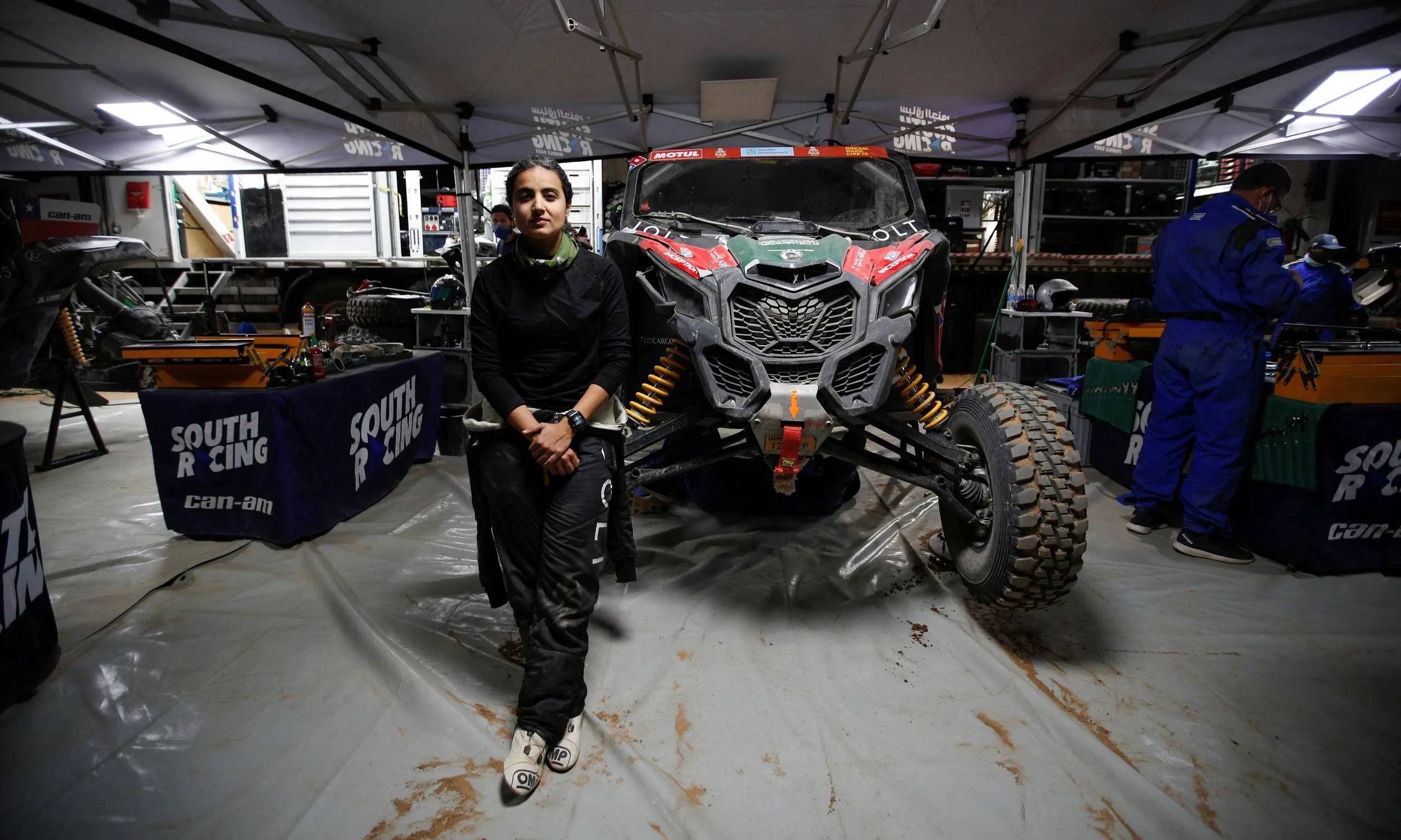 Mashael Alobaidan, one of the Saudi women participating in the Rally Dakar 2022 for the first time, poses with her race vehicle in Bisha.