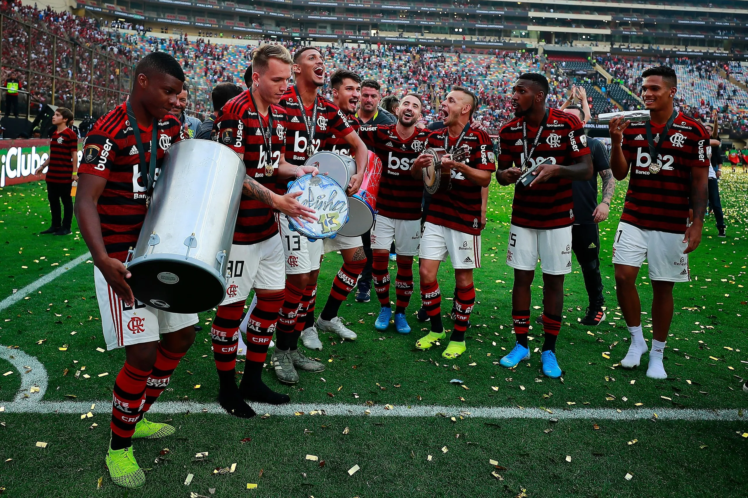 Lincoln, Matheus Dantas and Rafinha of Flamengo sing and play instruments as they celebrate their victory.