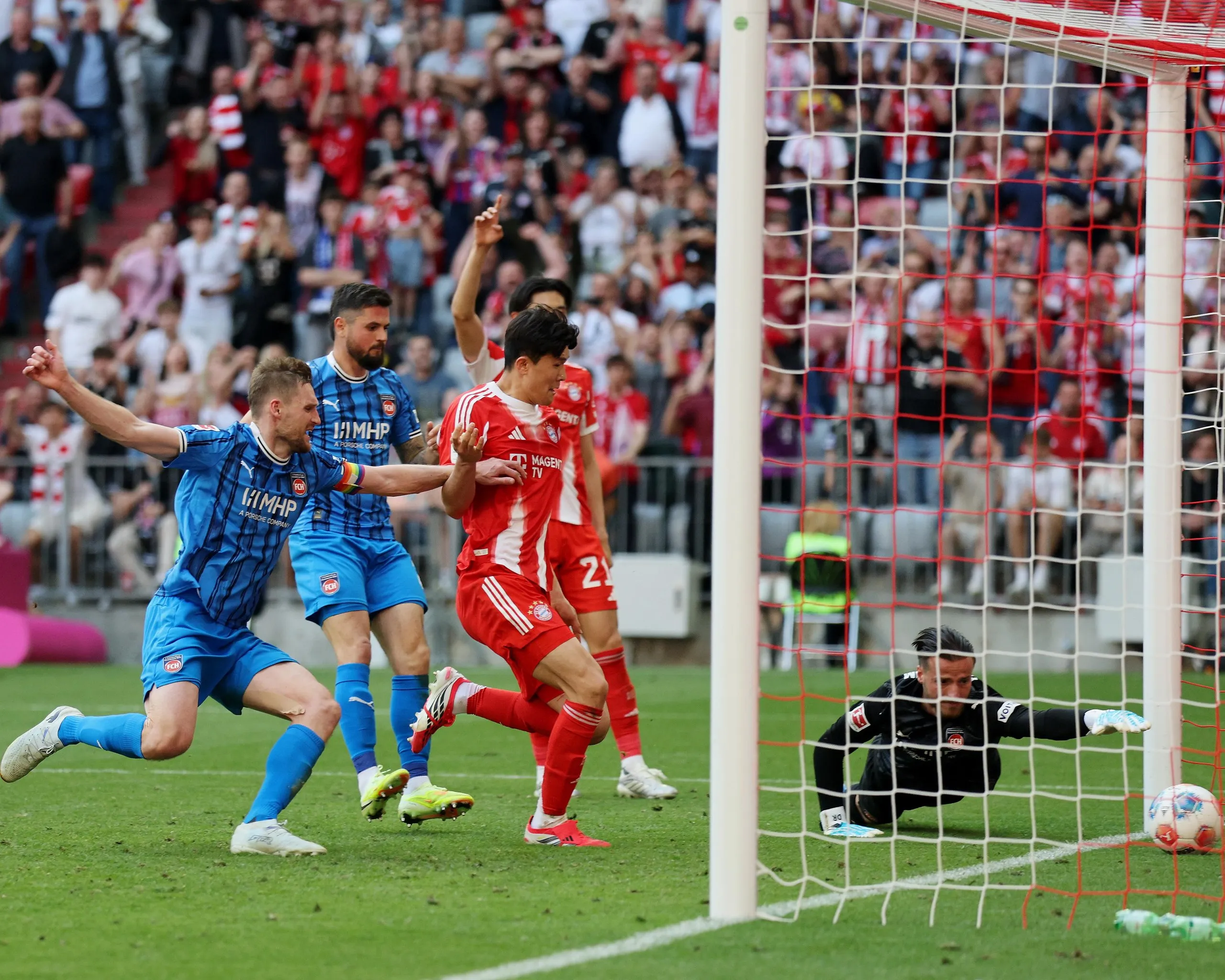 Diant Ramaj, the Heidenheim goalkeeper, dives in vain to stop the ball going over the line for Bayern Munich’s third goal in a 3-3 draw between the two teams in their Bundesliga game at the Allianz Arena.