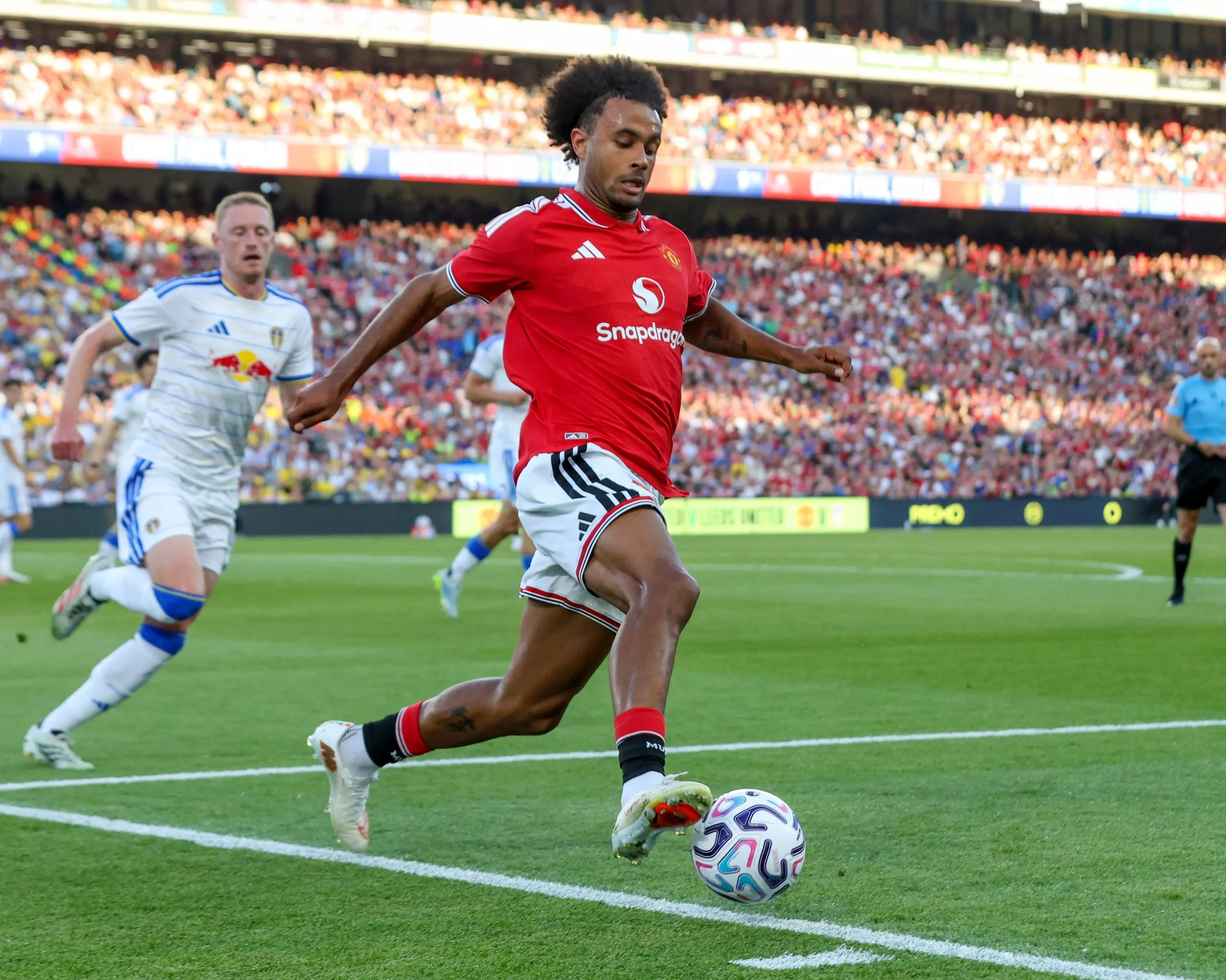 The Manchester United forward Joshua Zirkzee controls the ball under pressure from the Leeds United midfielder Sean Longstaff during a pre-season friendly.