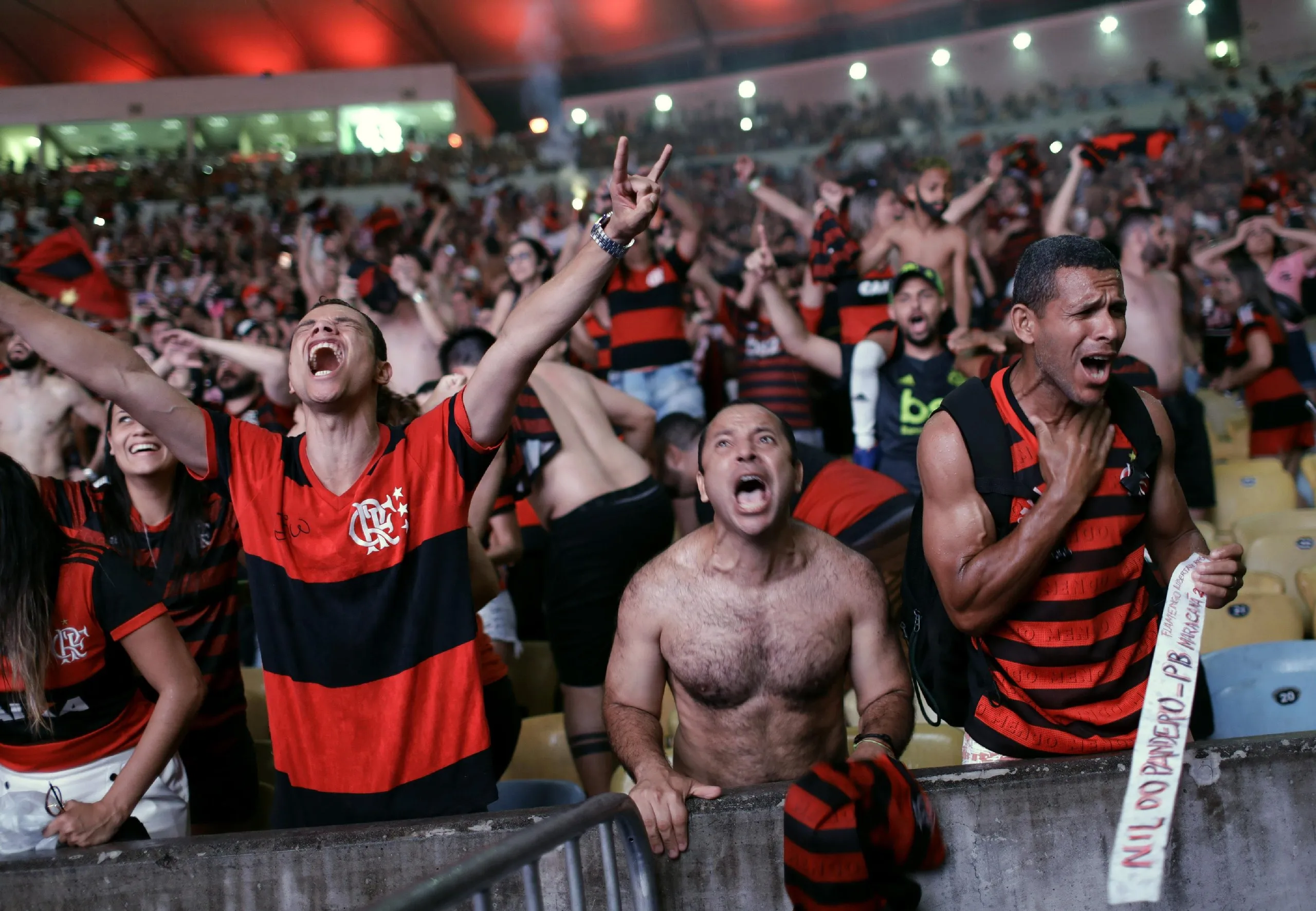 Flamengo fans watching the match on a giant screen at the Macarena Stadium, in Rio de Janeiro, celebrate after Gabriel Barbosa scores.