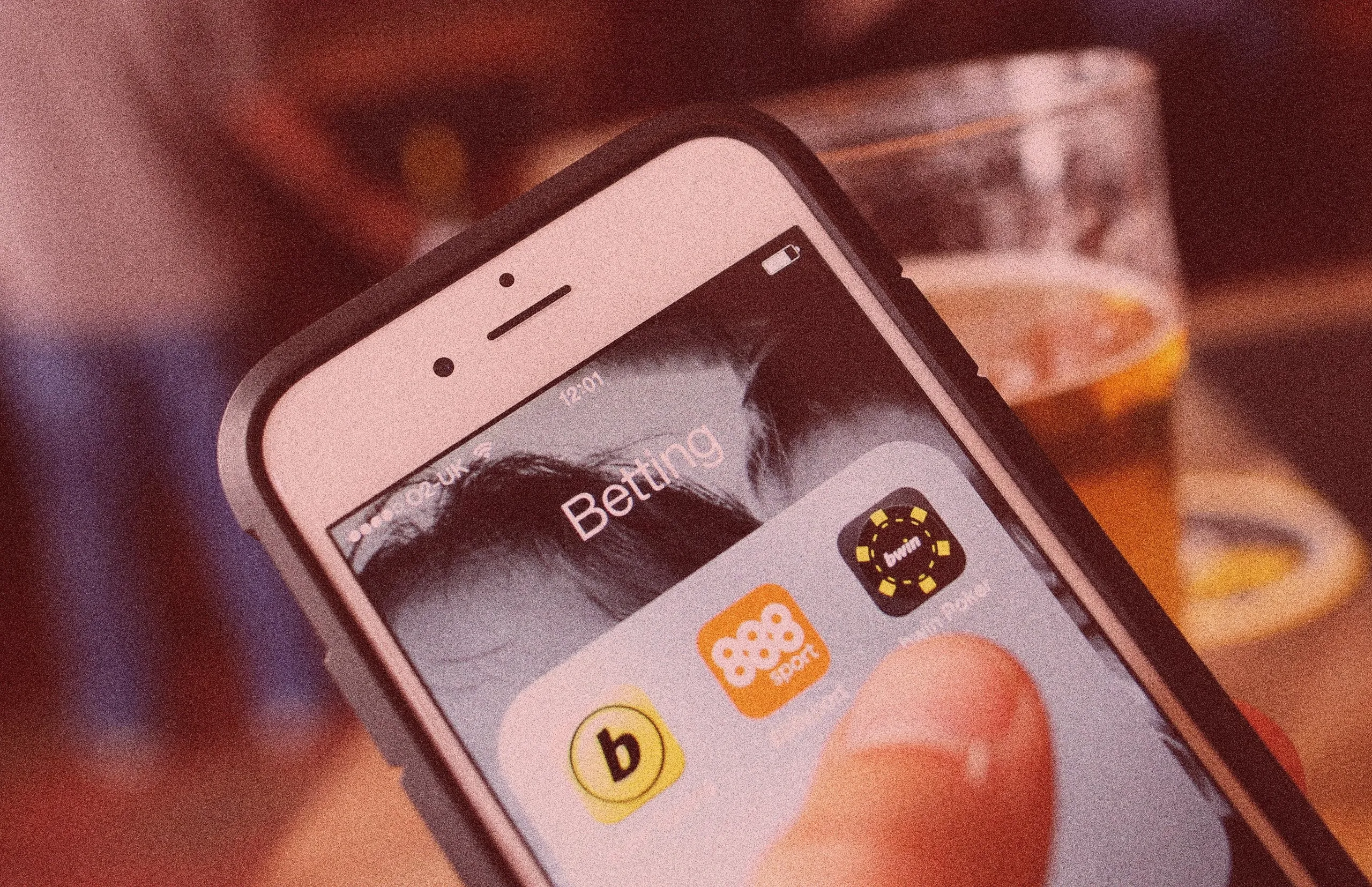 A phone with online gambling apps on the screen.