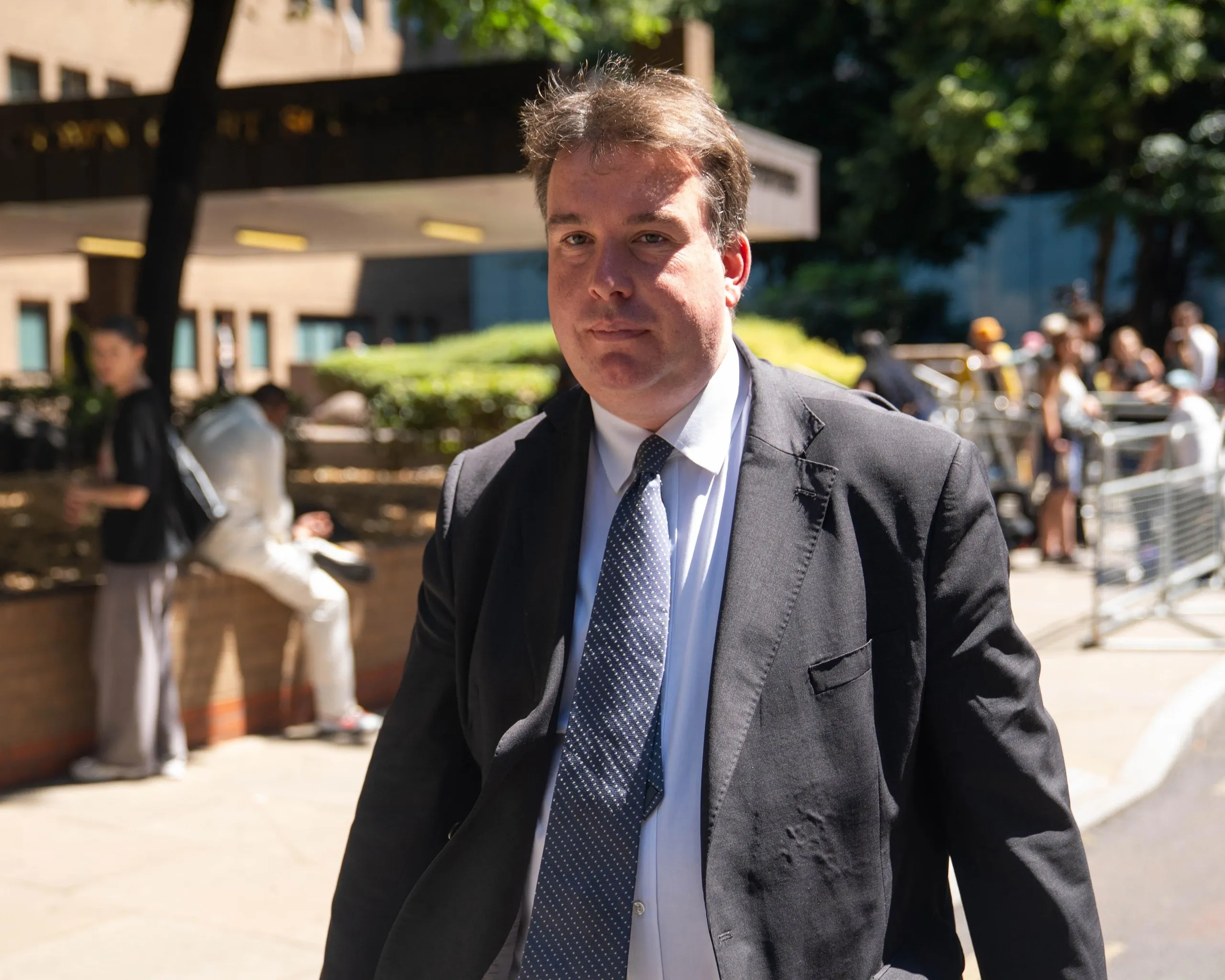Williams, wearing a suit and tie, walks outside the court