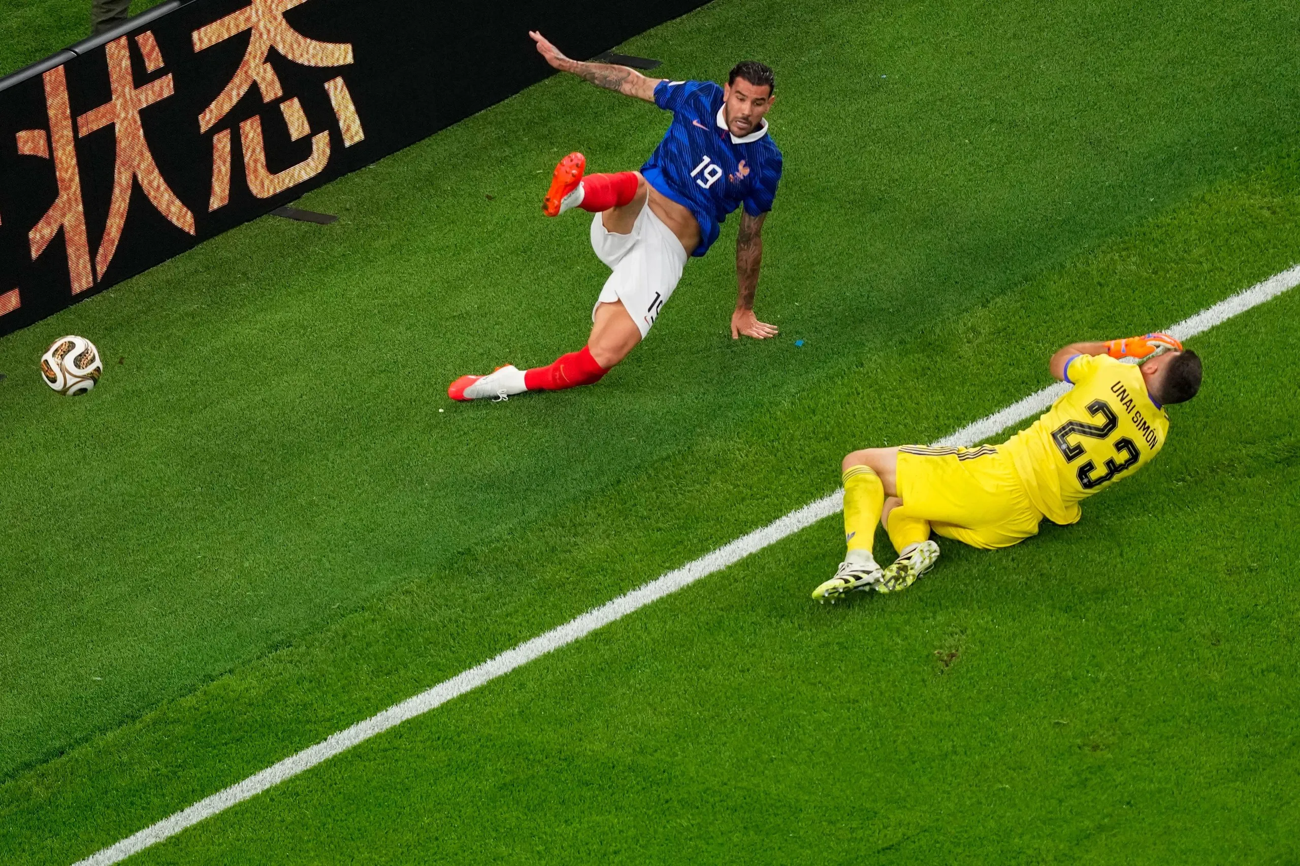 Spain’s goalkeeper Unai Simon falls after colliding with France's Theo Hernandez.