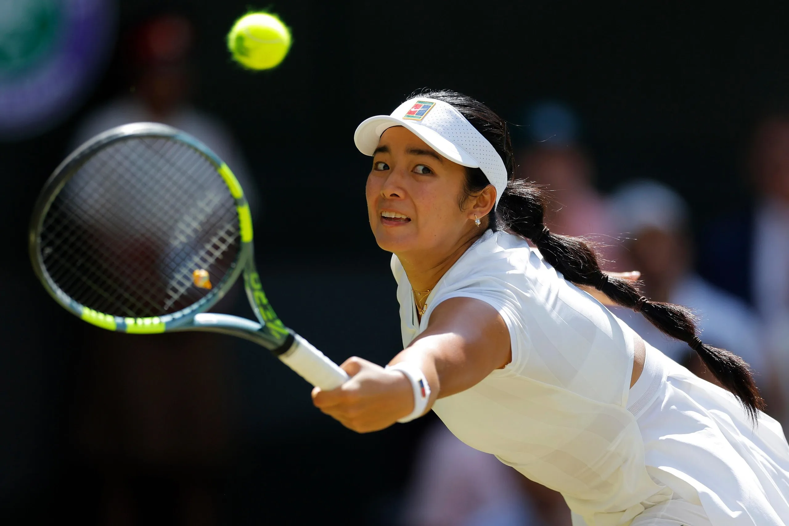 Alexandra Eala stretches for a backhand return to Iga Swiatek on Centre Court.