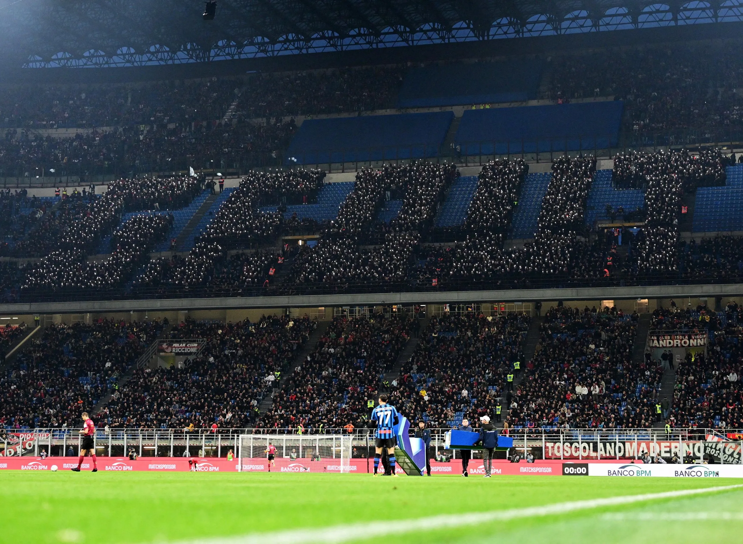 Milan fans use their mobile phone flashlights to spell the letters G.F. OUT before the Serie A match between Milan and Atalanta