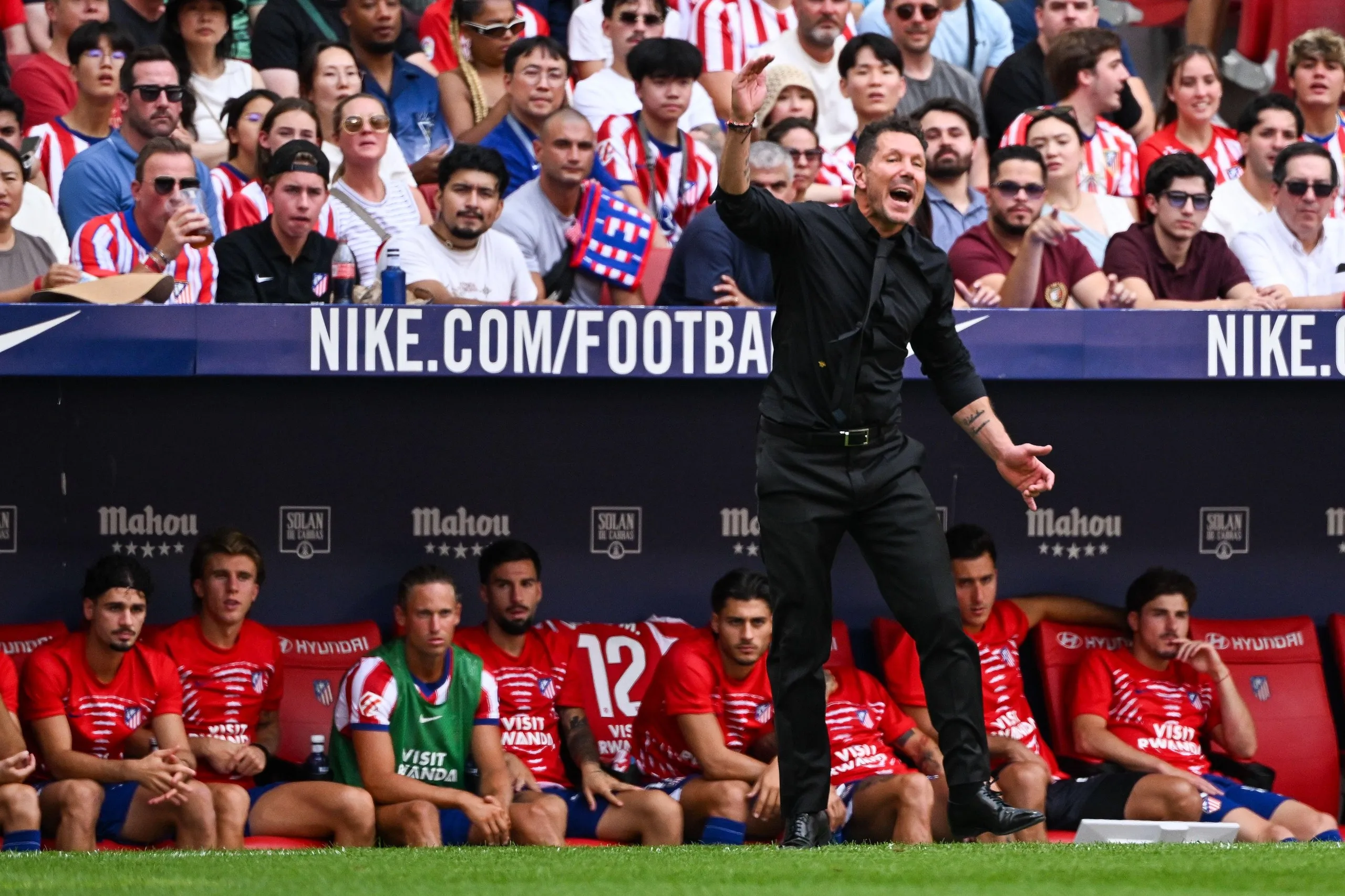 Diego Simeone stands in front of his substitutes.