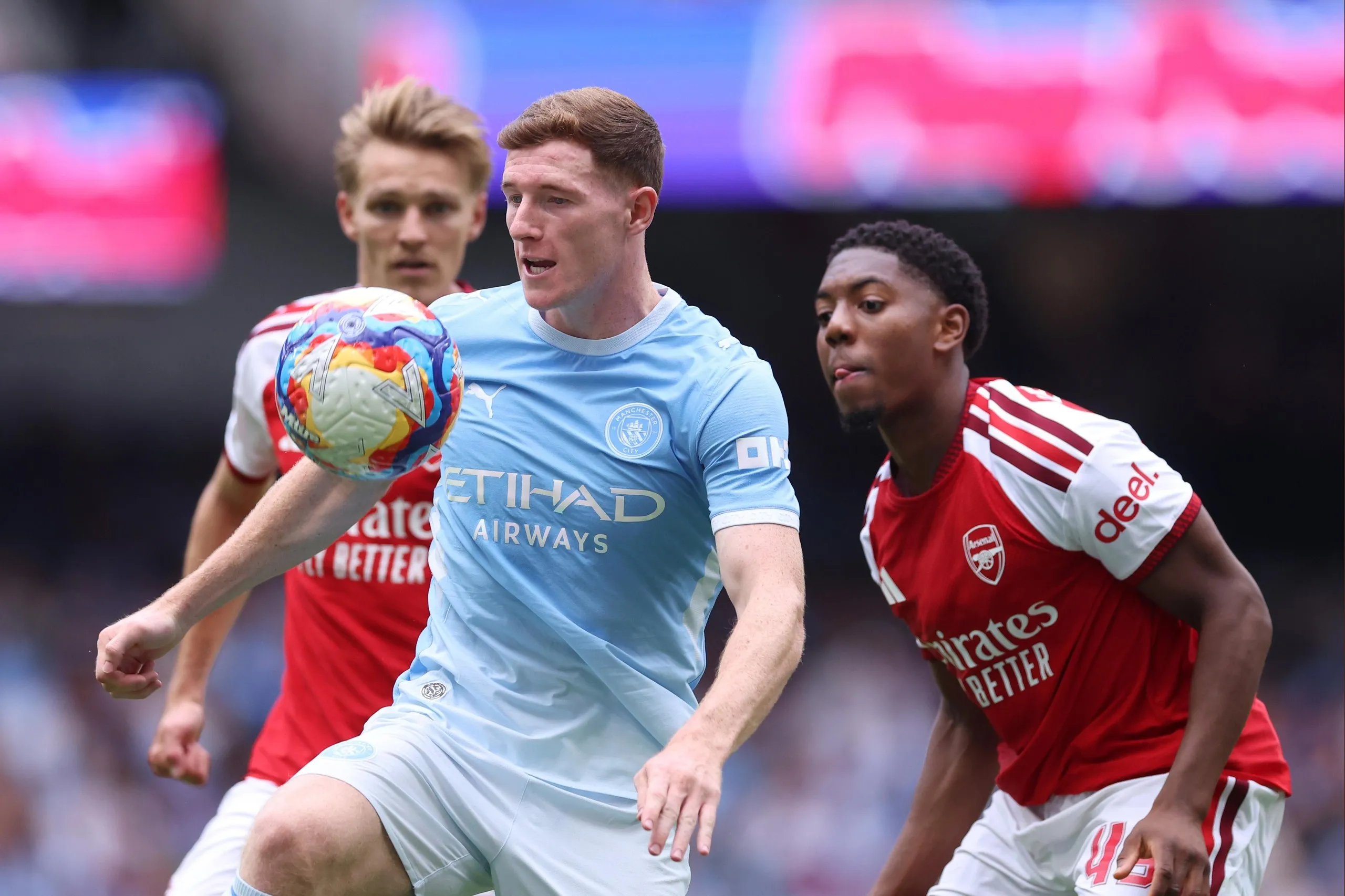 Elliot Anderson of Manchester City holds off Martin Ødegaard and Myles Lewis-Skelly of Arsenal during the 2026 FA Community Shield