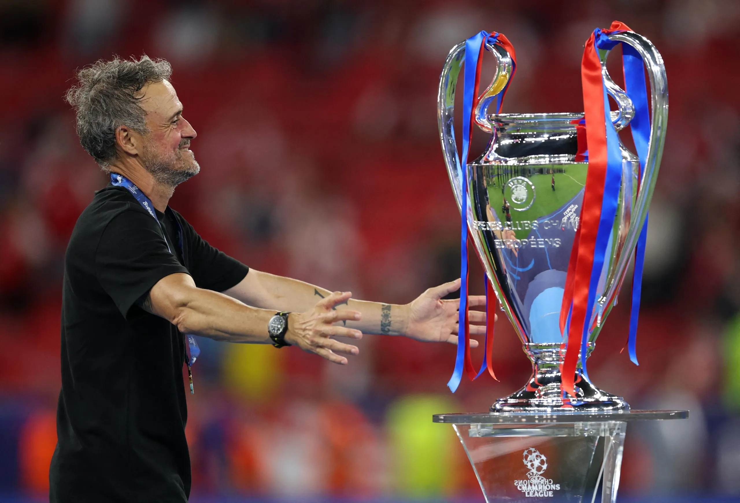 Paris St Germain coach Luis Enrique celebrates with the trophy after winning the Champions League.