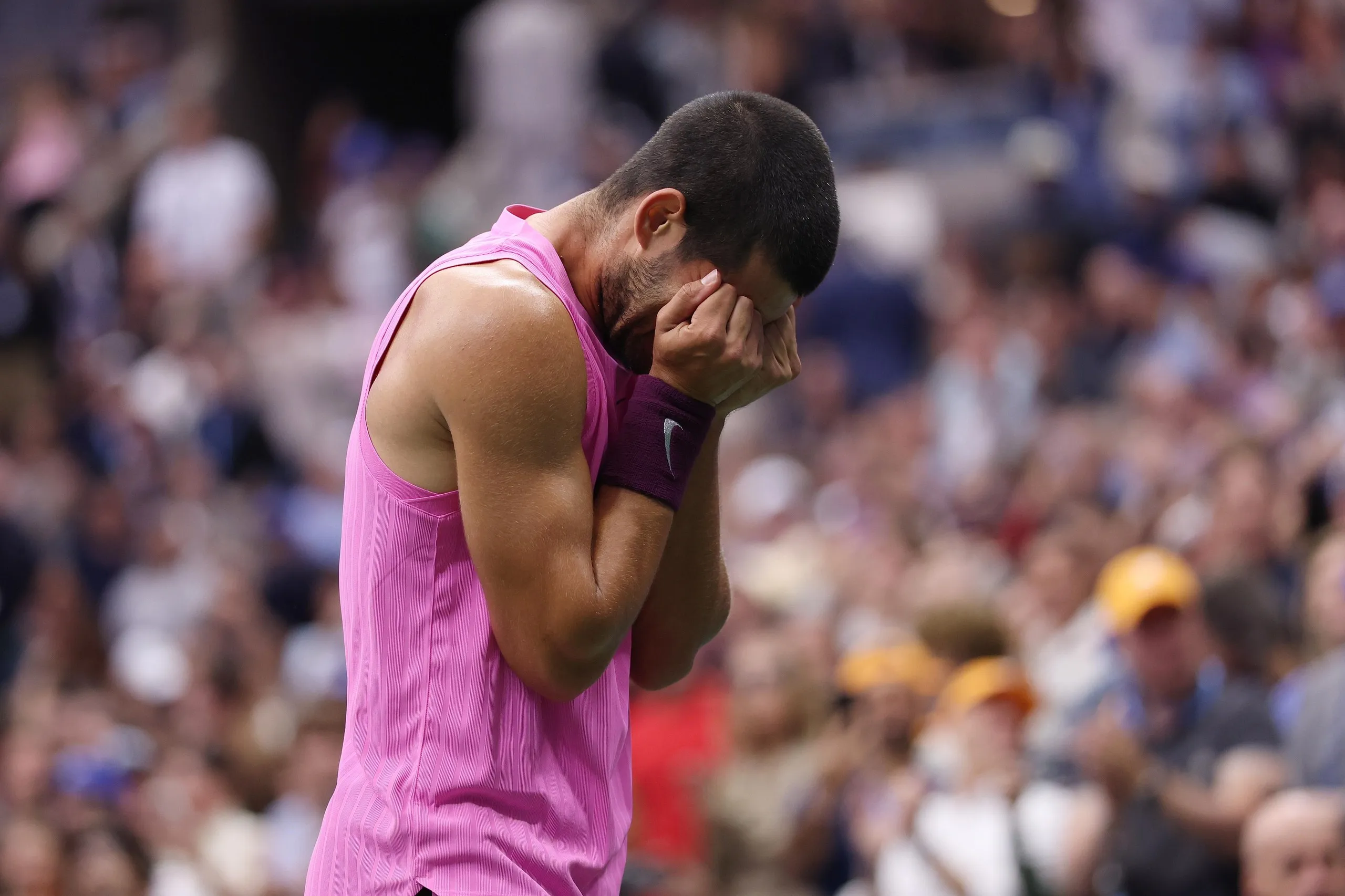 Alcaraz covers his eyes after winning match point against Jannik Sinner.