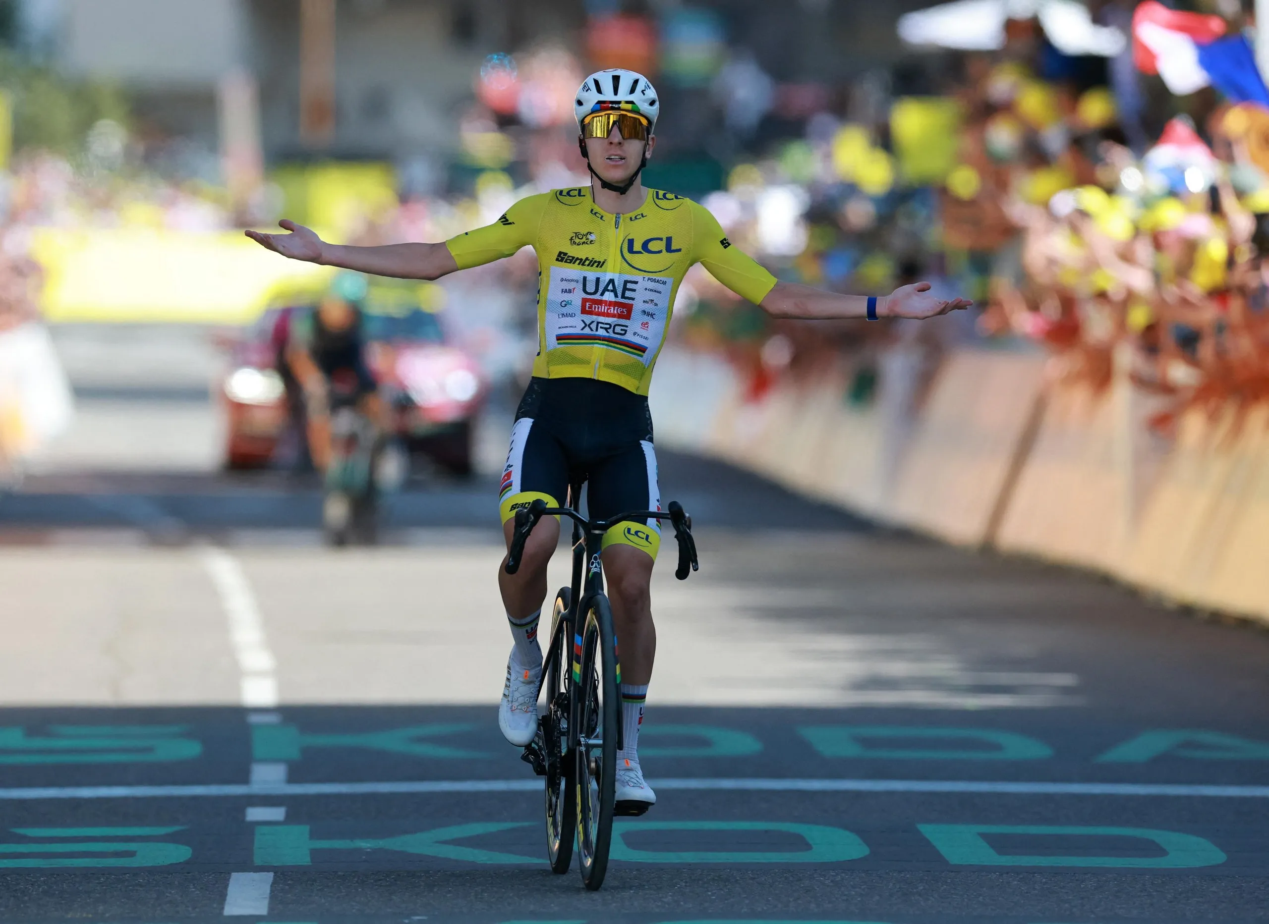 UAE Team Emirates XRG's Tadej Pogacar celebrates as he crosses the finish line after stage 19.