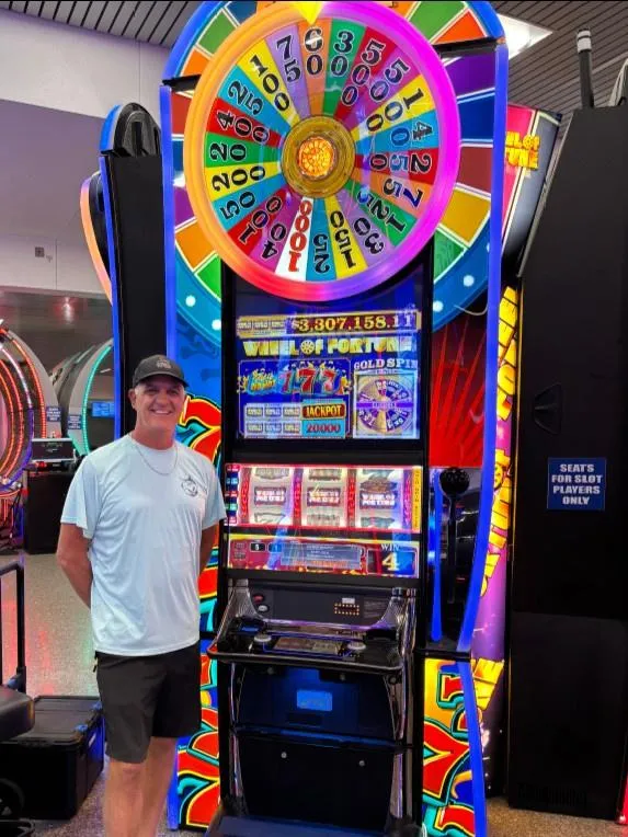 a man stands next to a slot machine