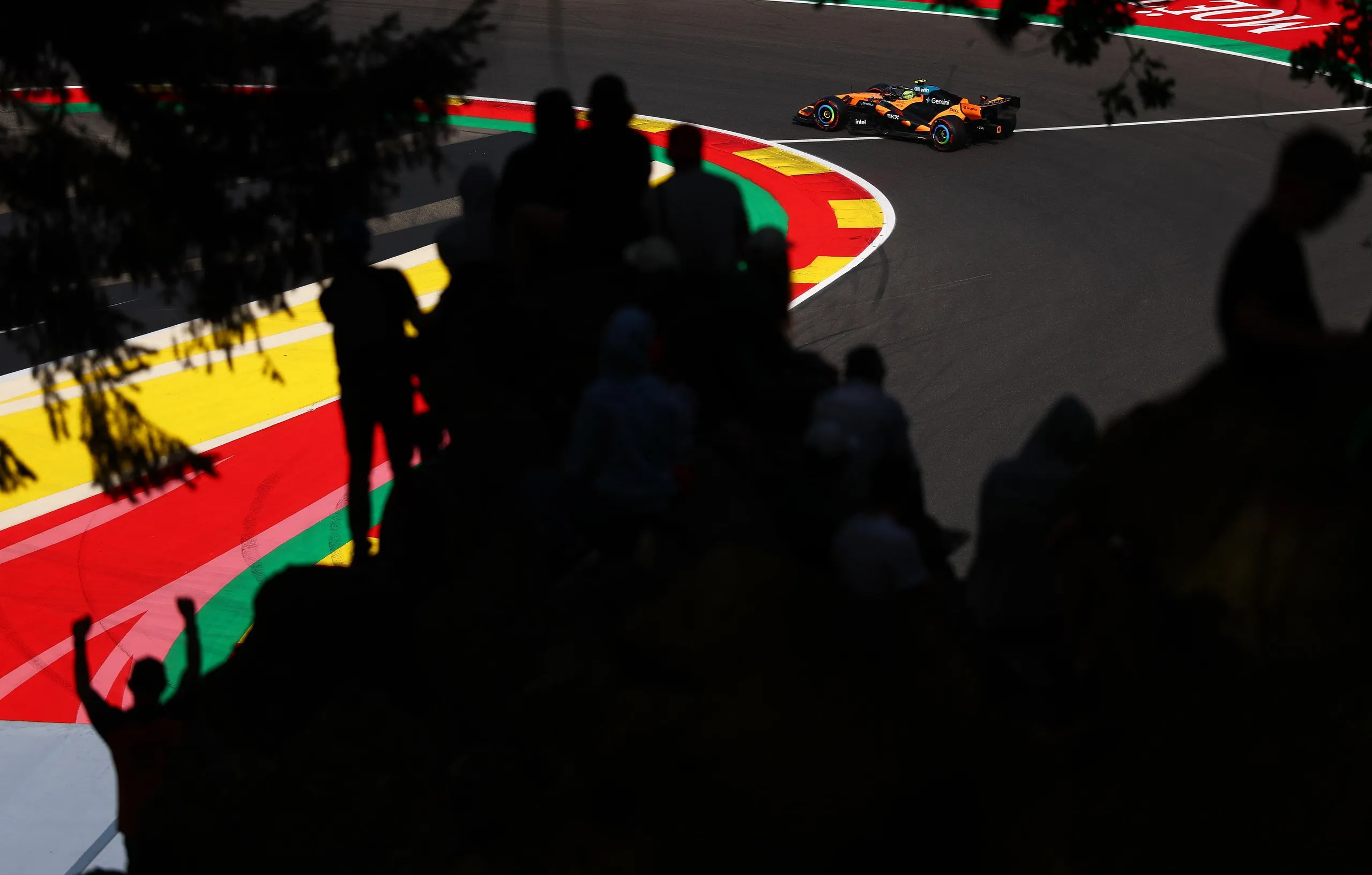 Fans watch Lando Norris negotiate a corner in his McLaren MCL40.