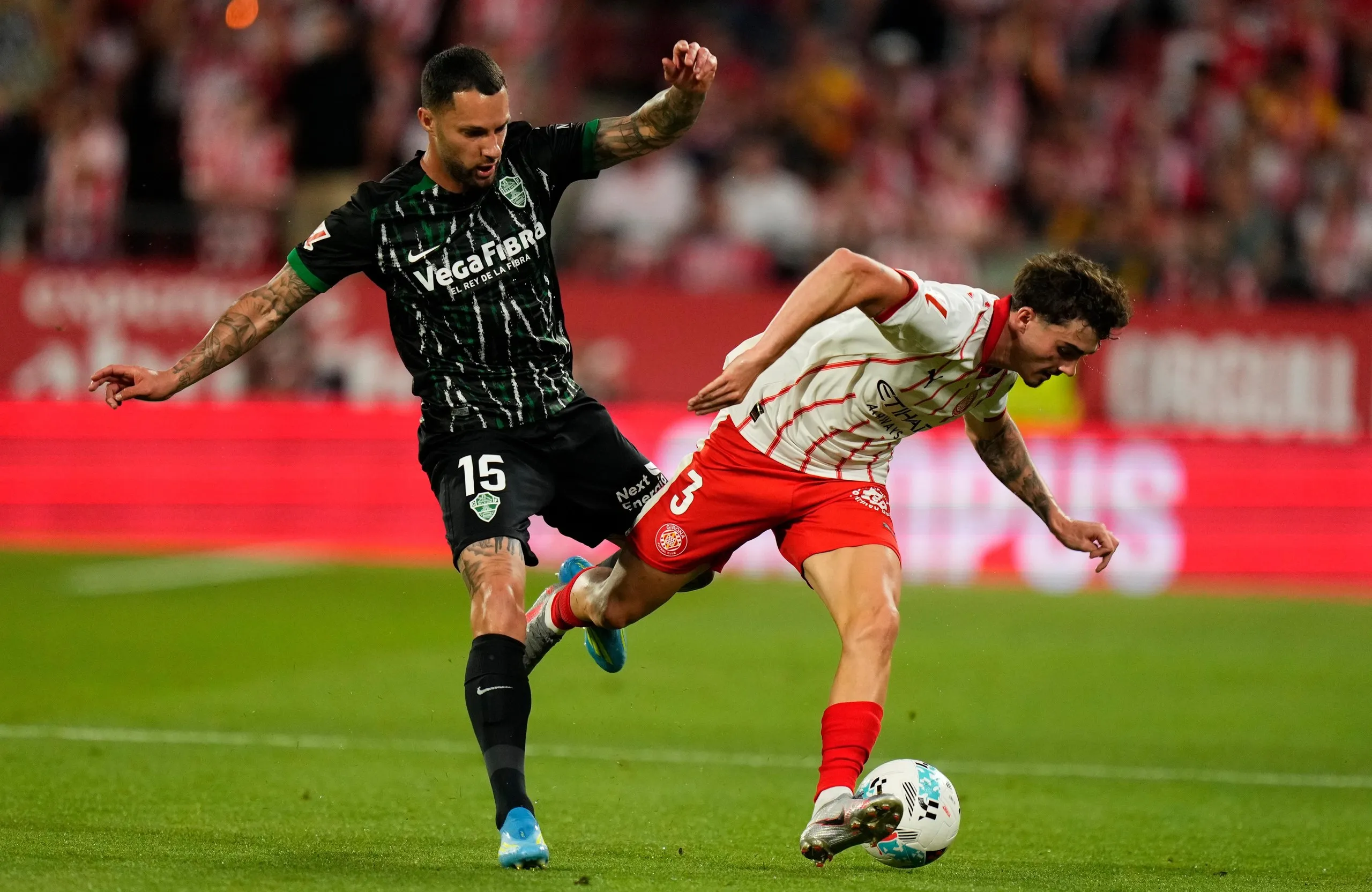 Girona’s Joel Roca is challenged by Elche’s José Antonio Morente.