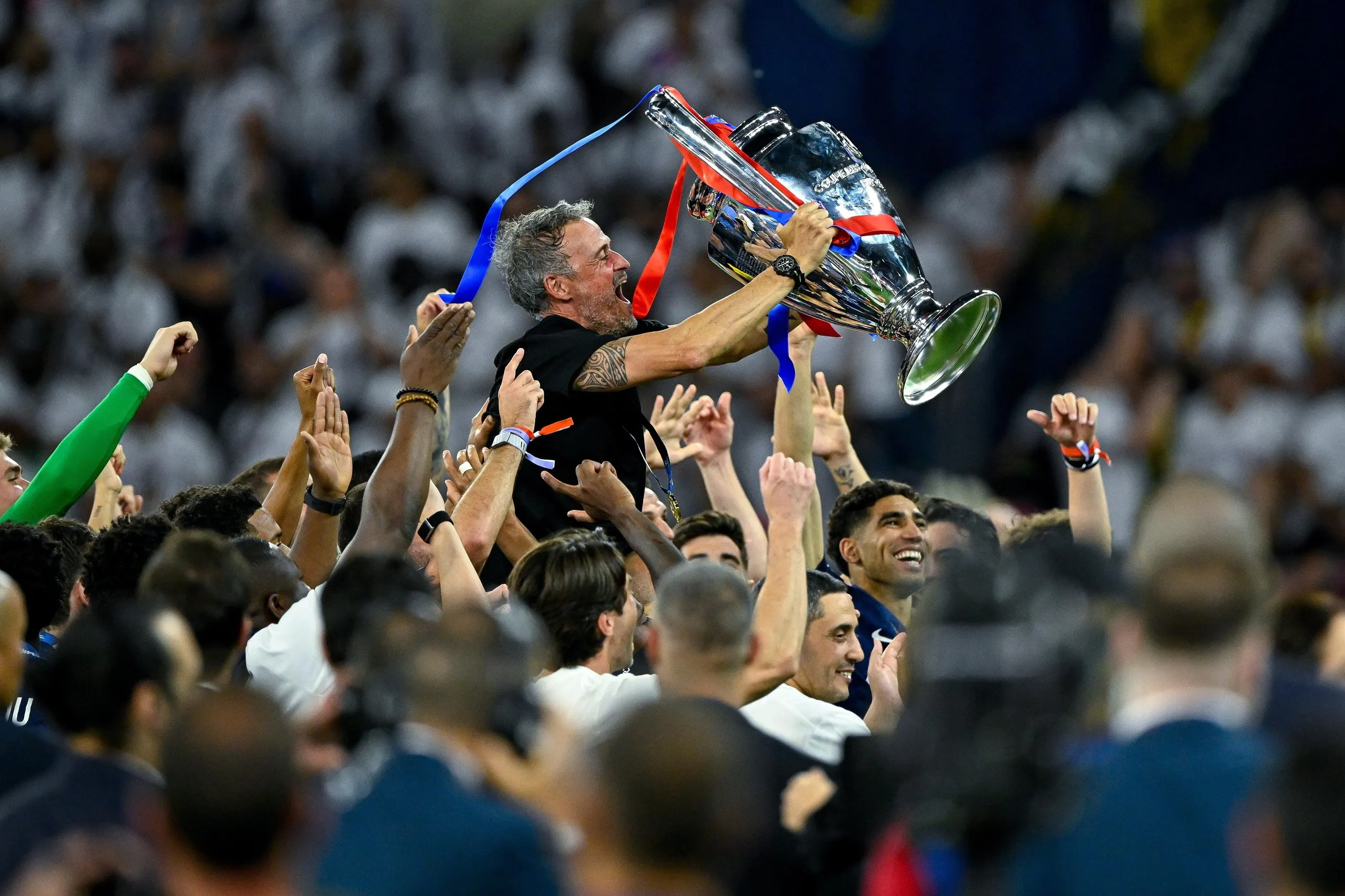 PSG's head coach Luis Enrique celebrates with the trophy after winning the Champions League final against Arsenal.