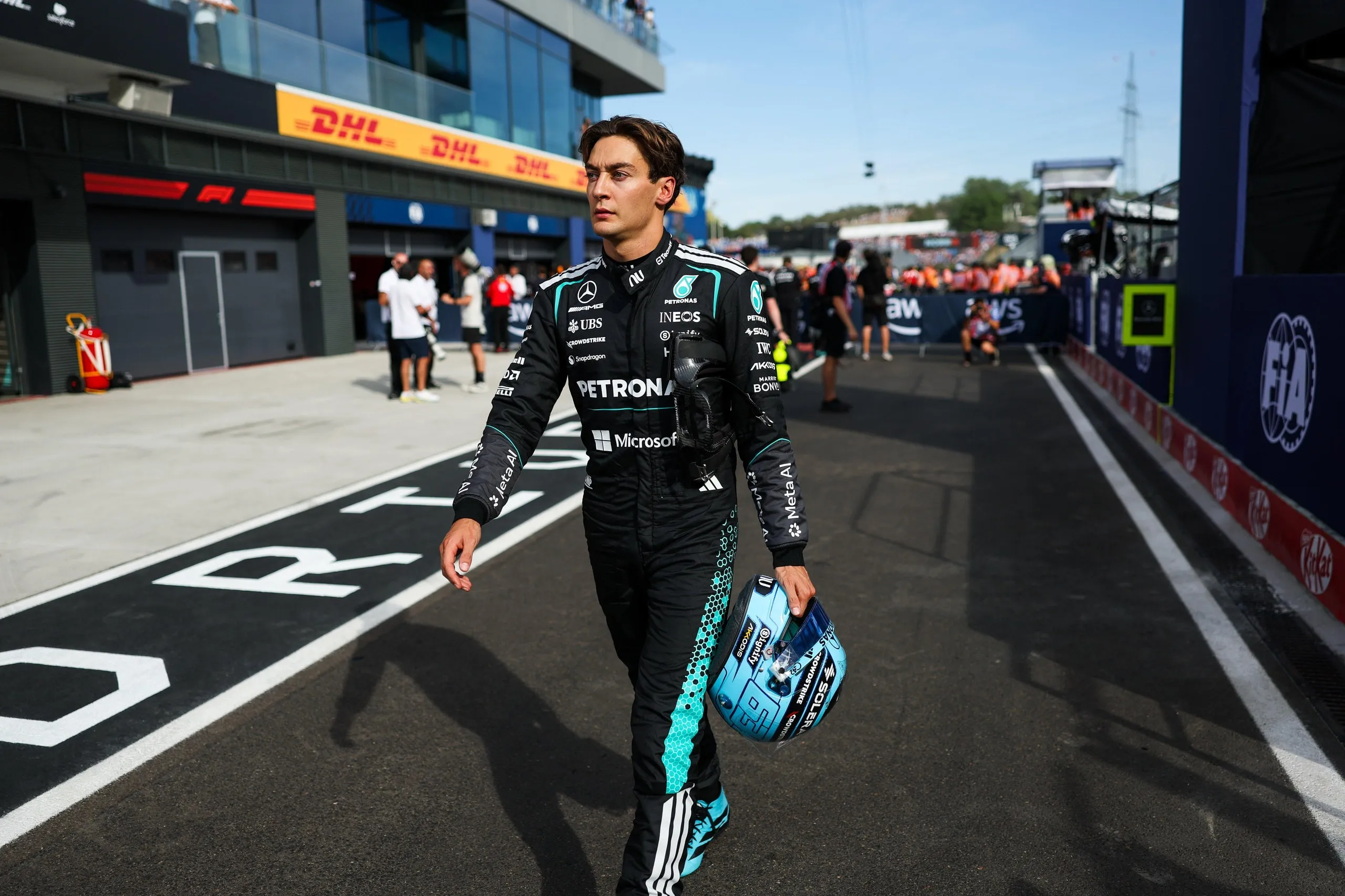 George Russell walks in the paddock