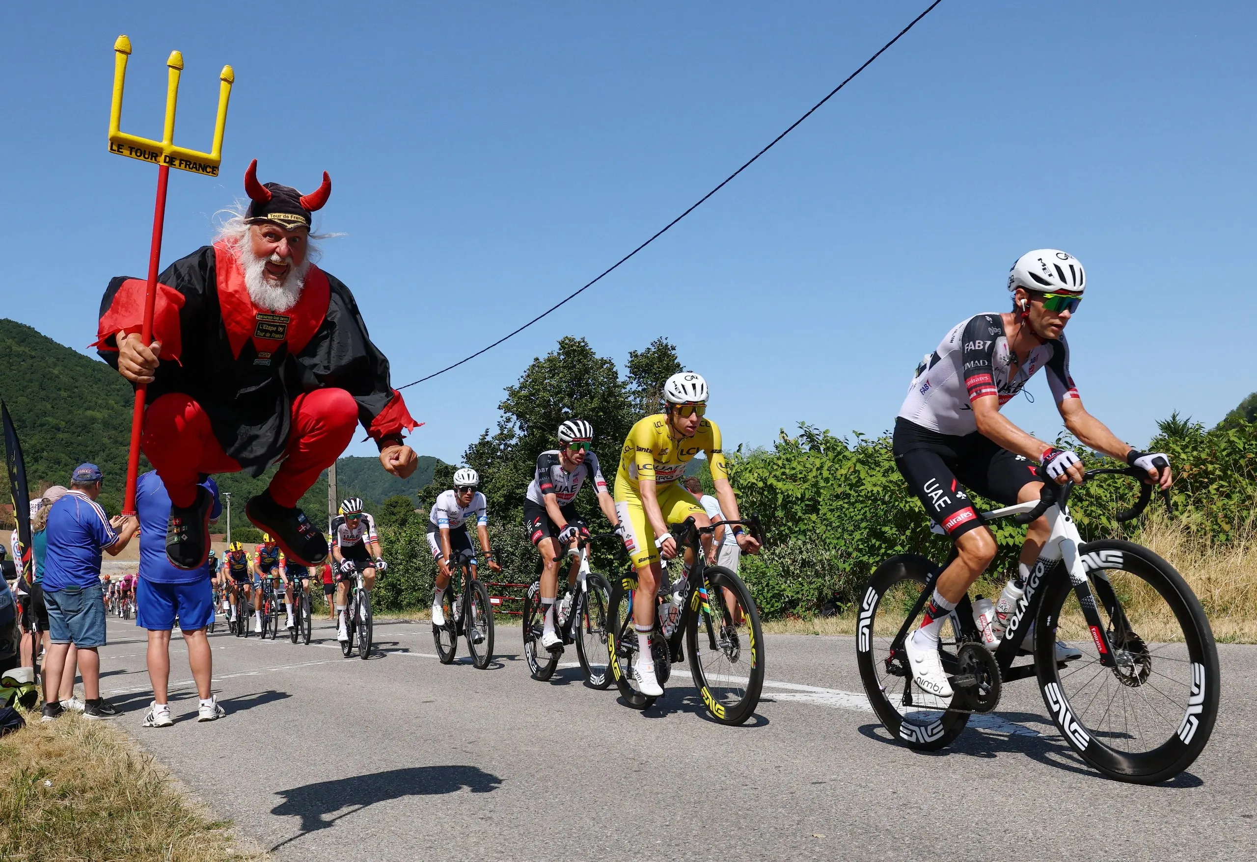 Didi Senft cheers from the side of the road as Tadej Pogacar passes