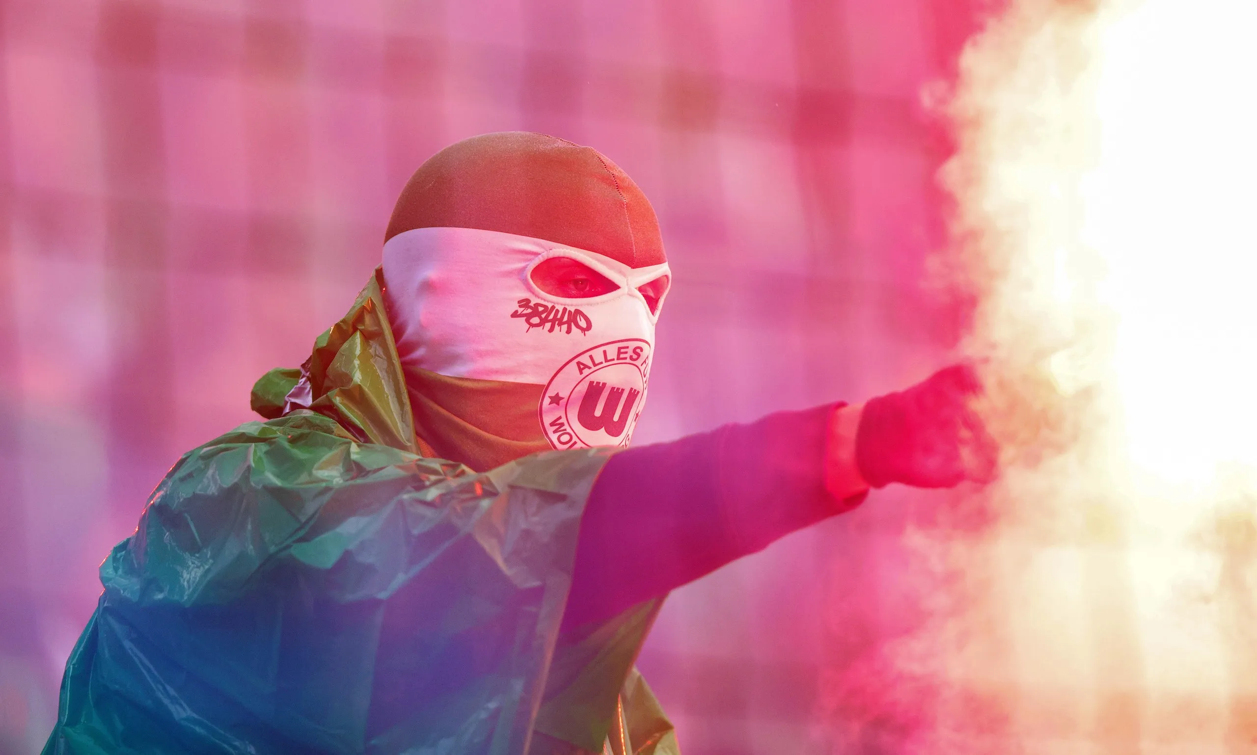 A Wolfsburg fan with a flare in the away end at St Pauli