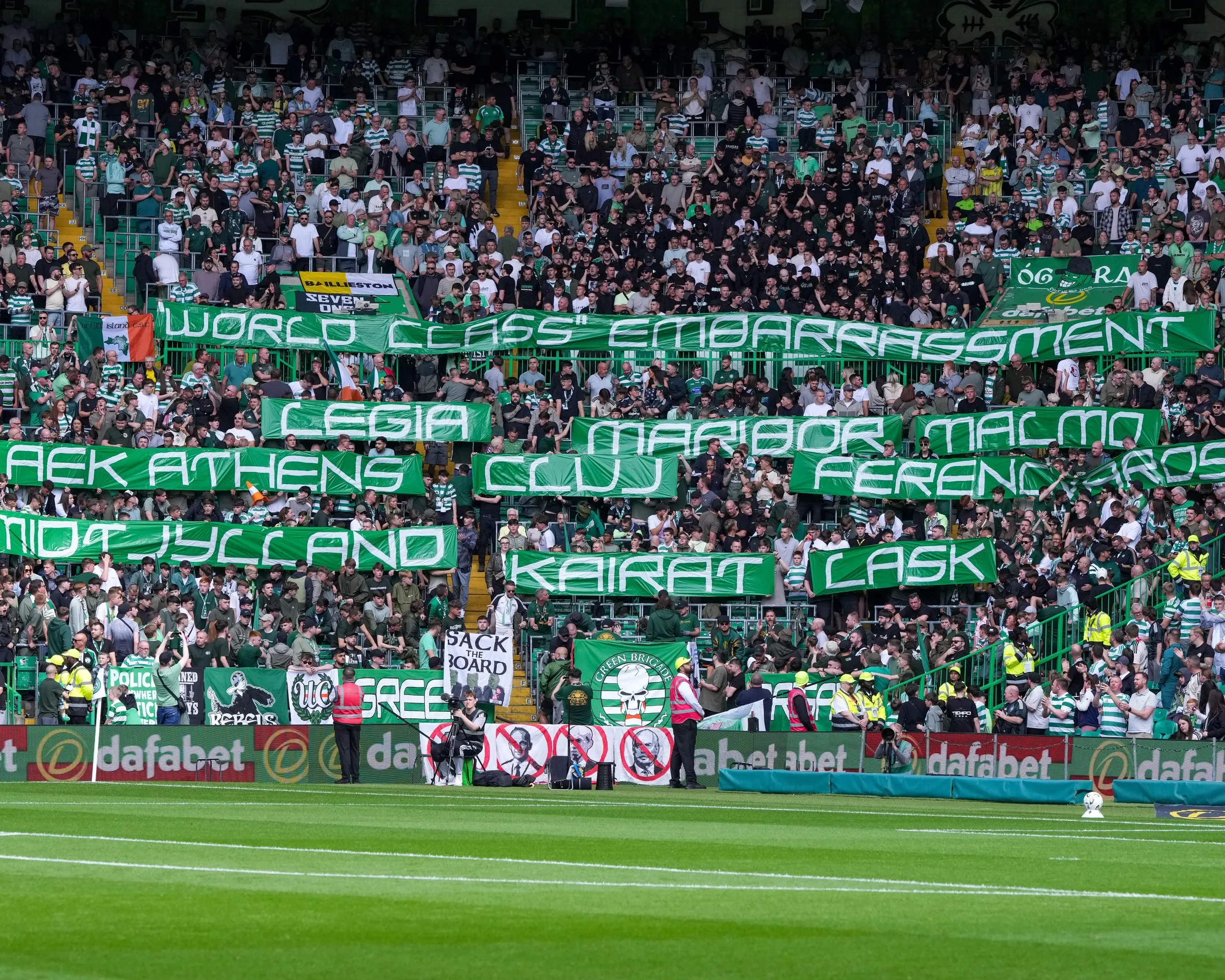 Fans hold up banners with the names of teams that have eliminated Celtic from Europe
