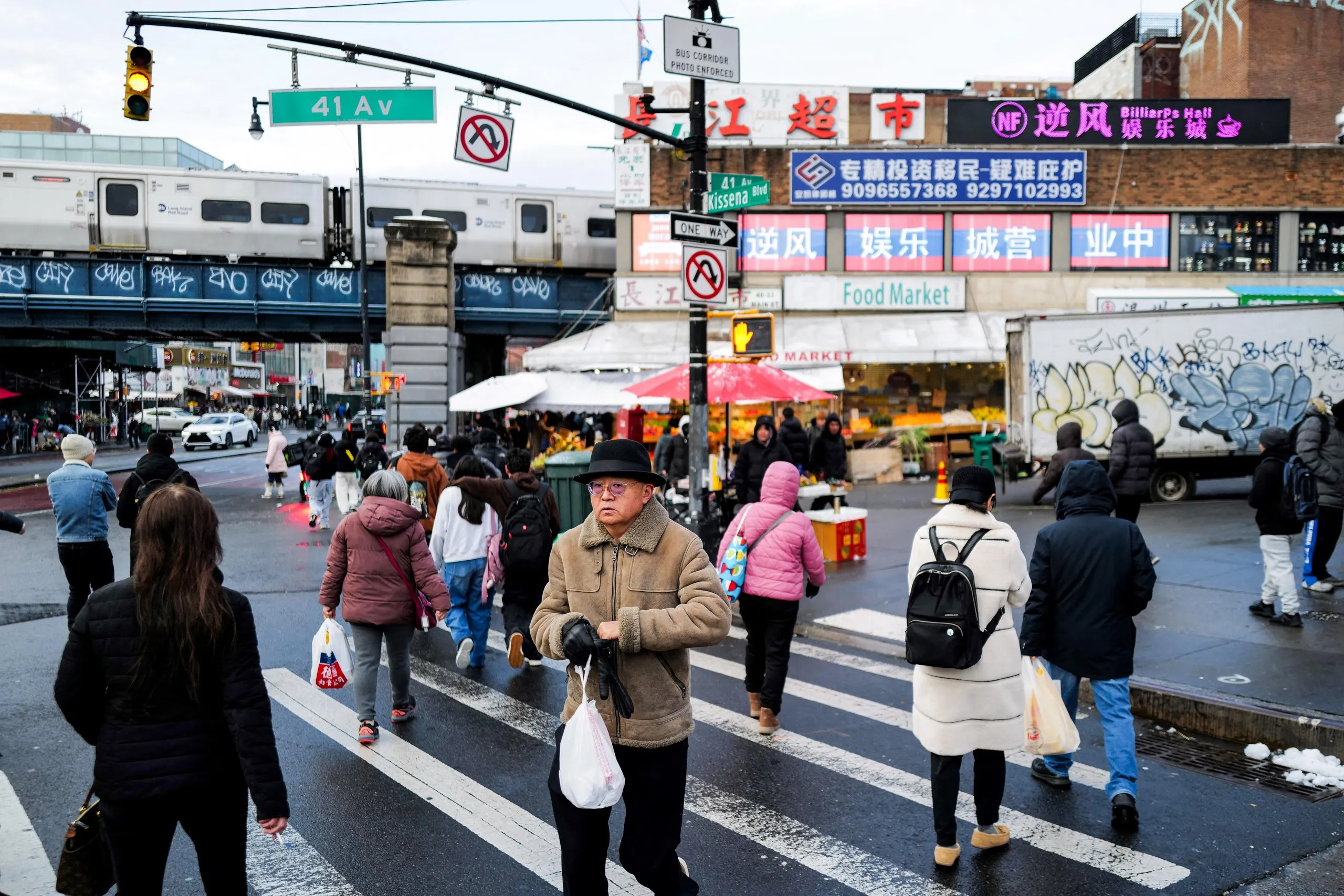 People at a street intersection with many signs in Chinese.
