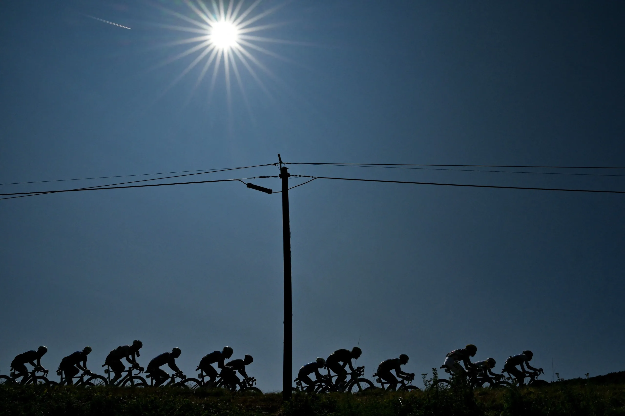 Riders silhouetted under the sun