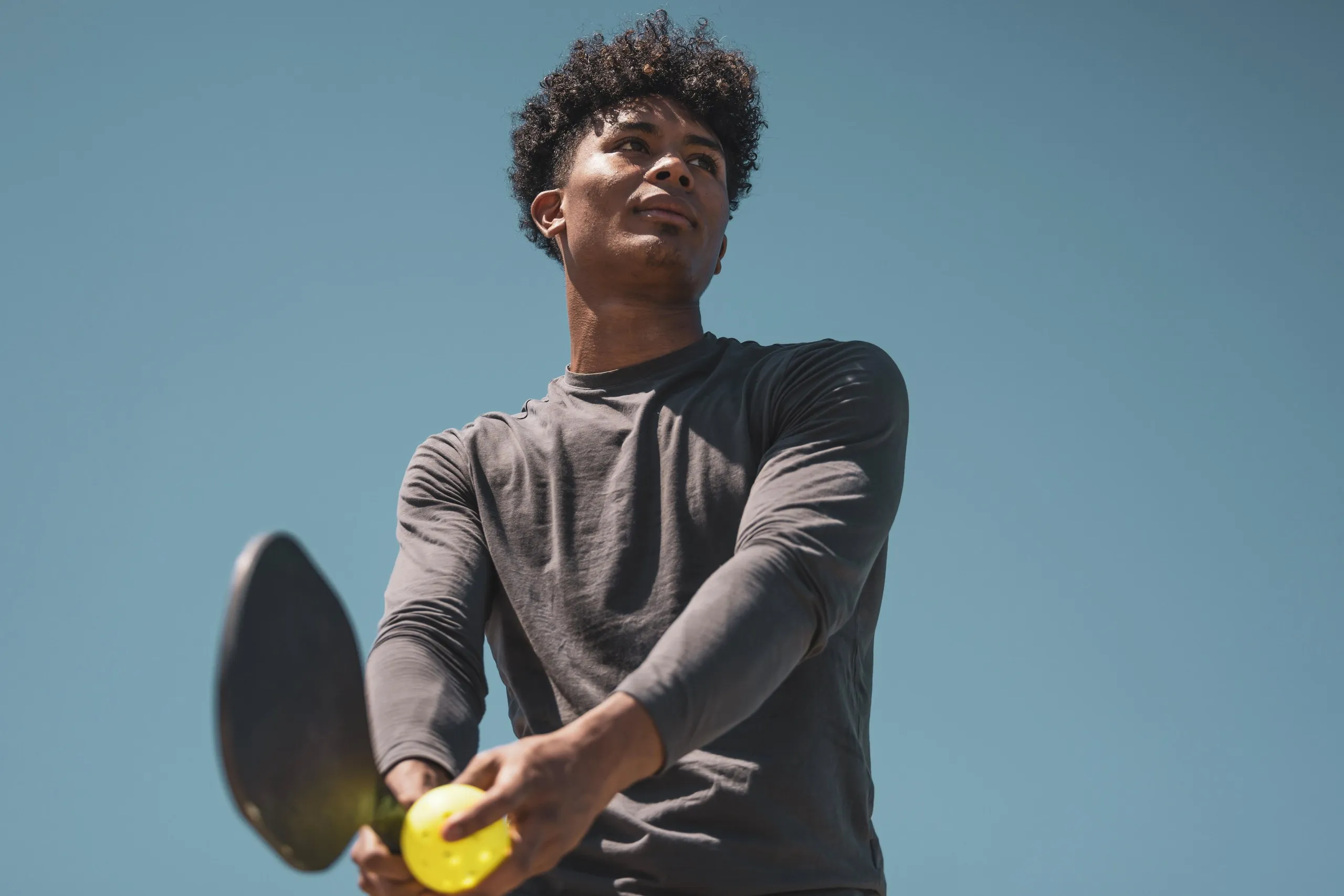 A pickleball player ready to serve in a game