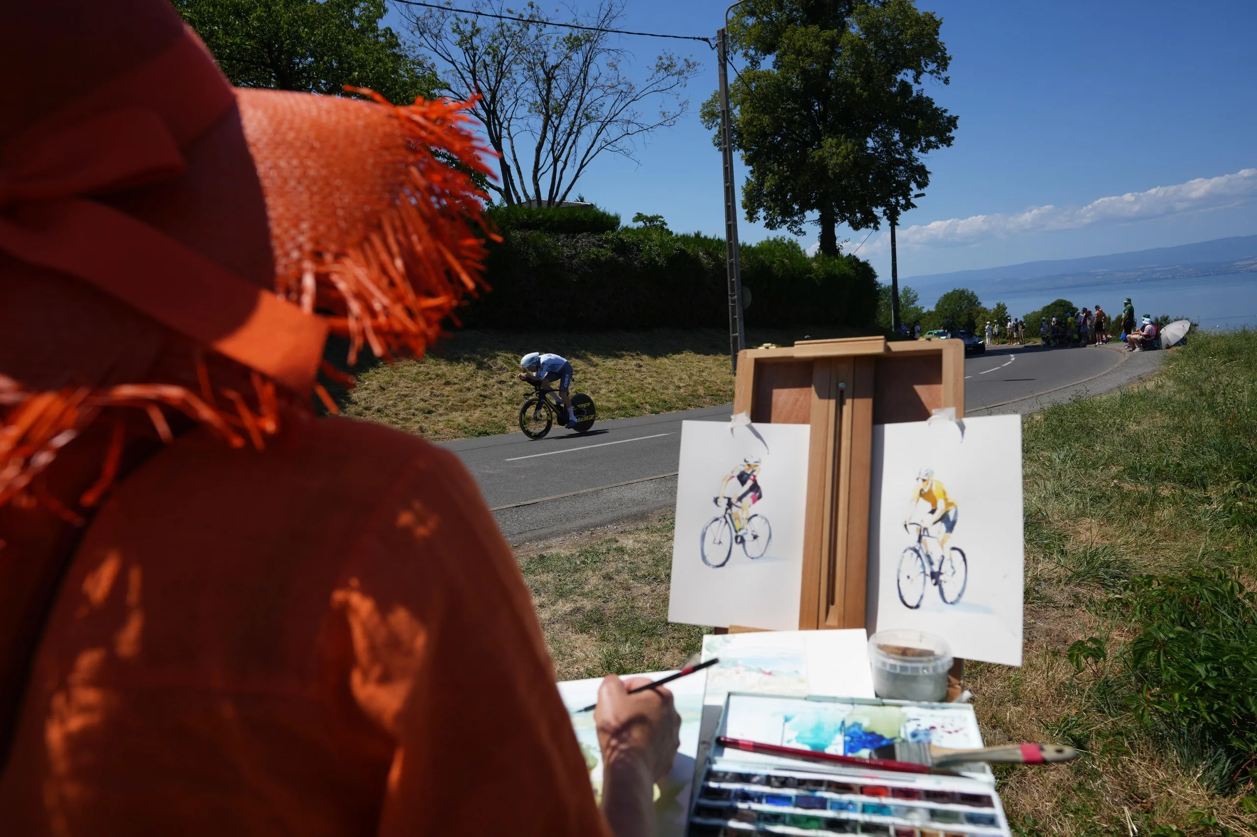 An artist paints as Fred Wright rides past on the way to Thonon-les-Bains.