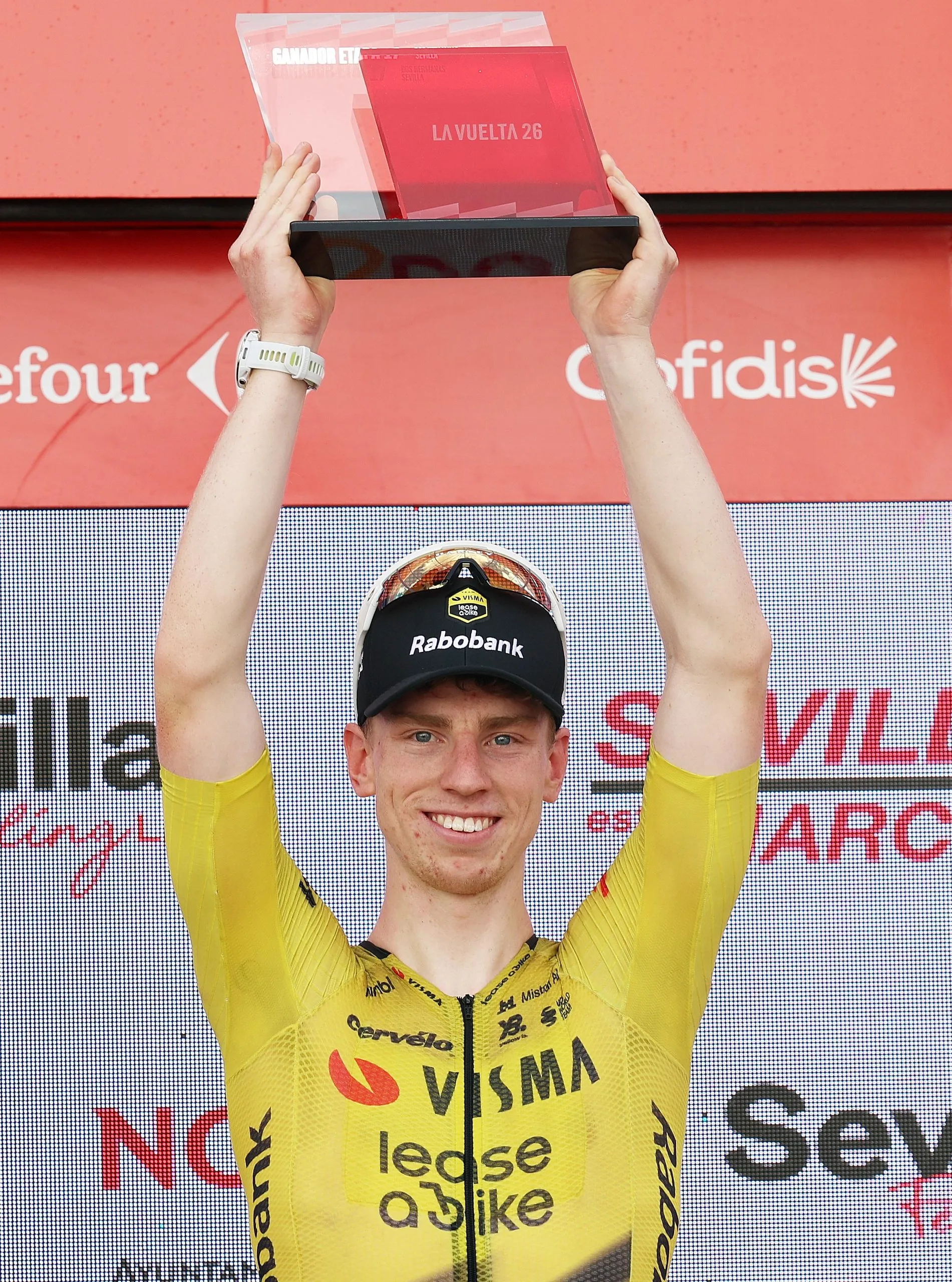 Matthew Brennan celebrates on the podium at Sevilla after winning his fifth stage of this year’s Vuelta.