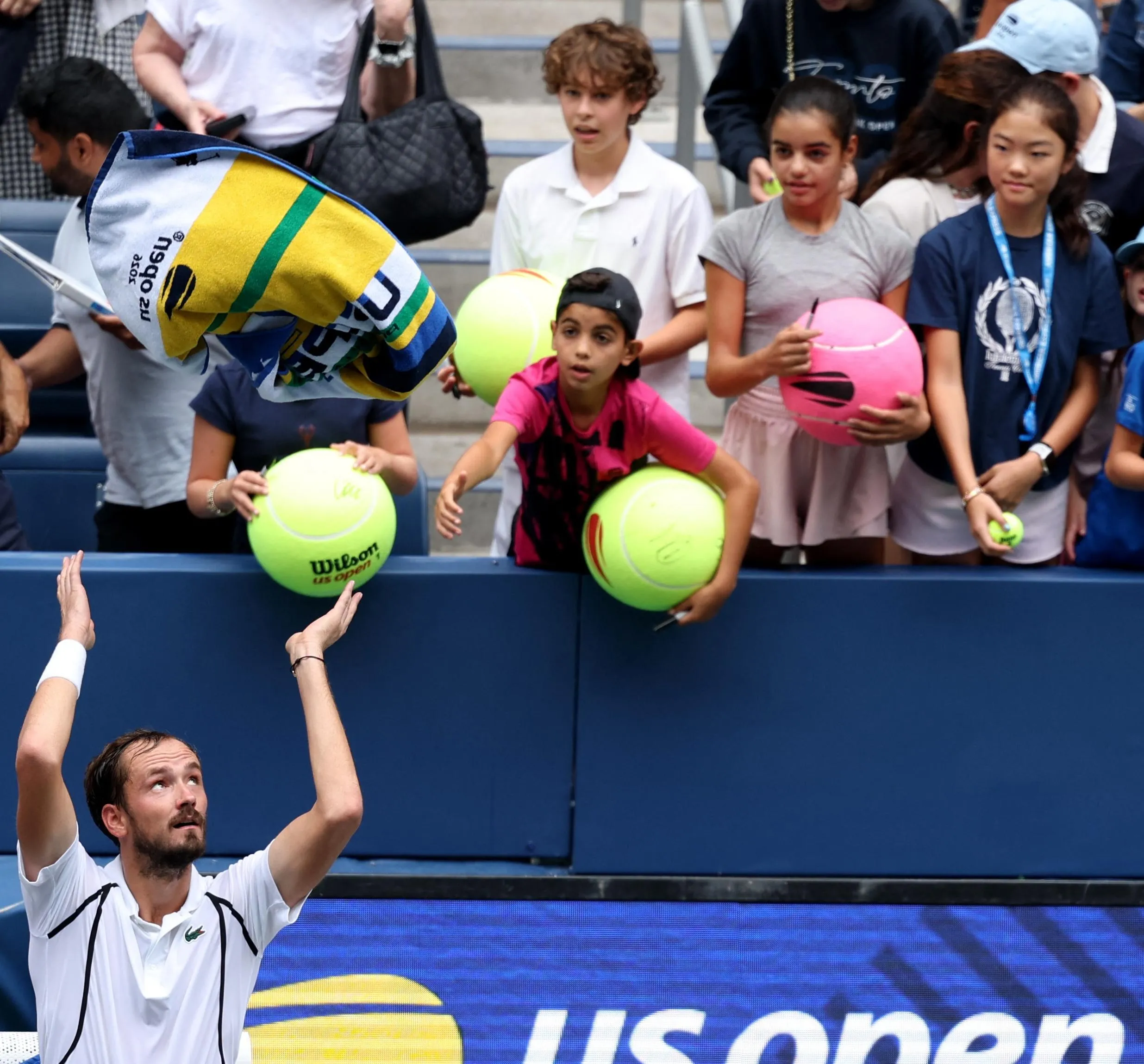 Daniil Medvedev throws a towel to fans after winning his second round match against Sebastian Gorzny.