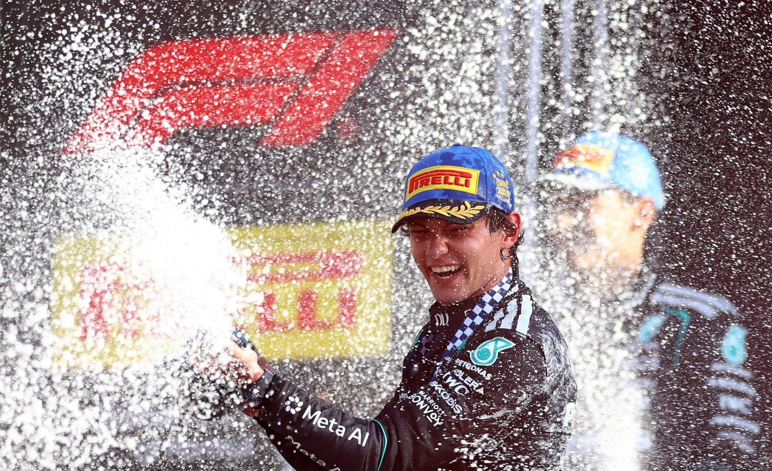 Kimi Antonelli celebrates with champagne on the podium at the Italian Grand Prix.