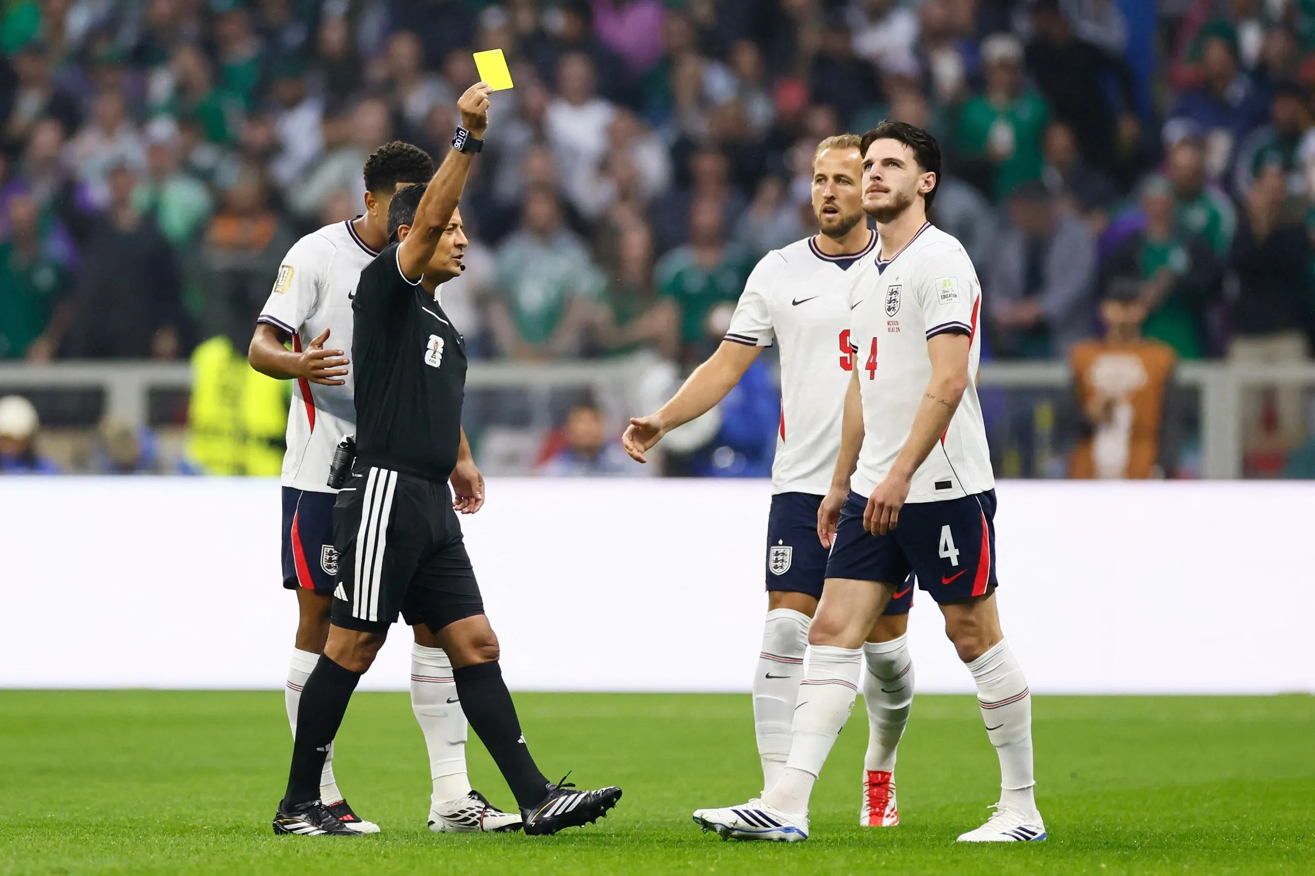 Alireza Faghani shows a yellow card to Declan Rice