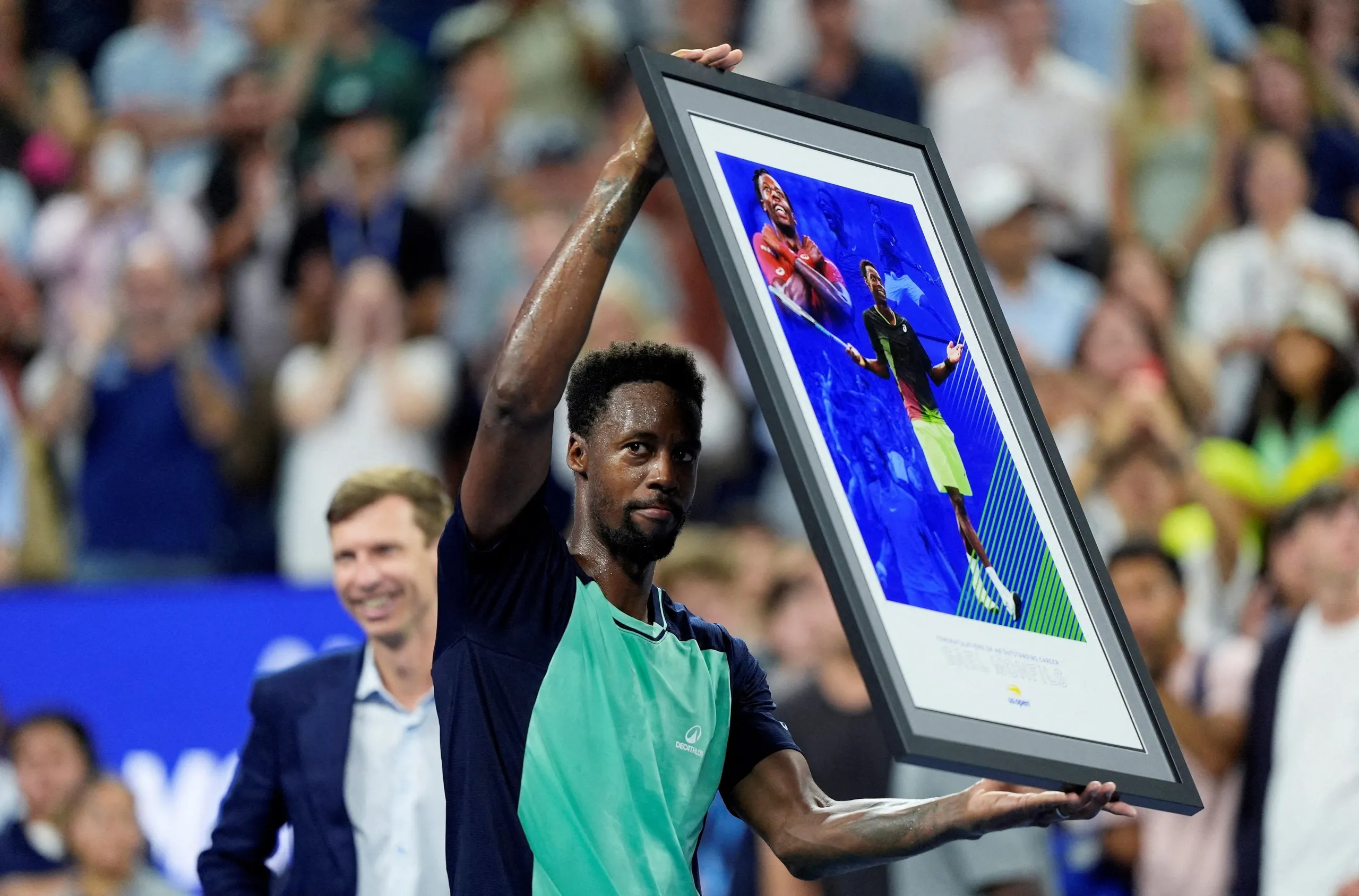 Gaël Monfils is presented with a gift after his second-round defeat by Learner Tien, having announced he will retire at the end of the season.