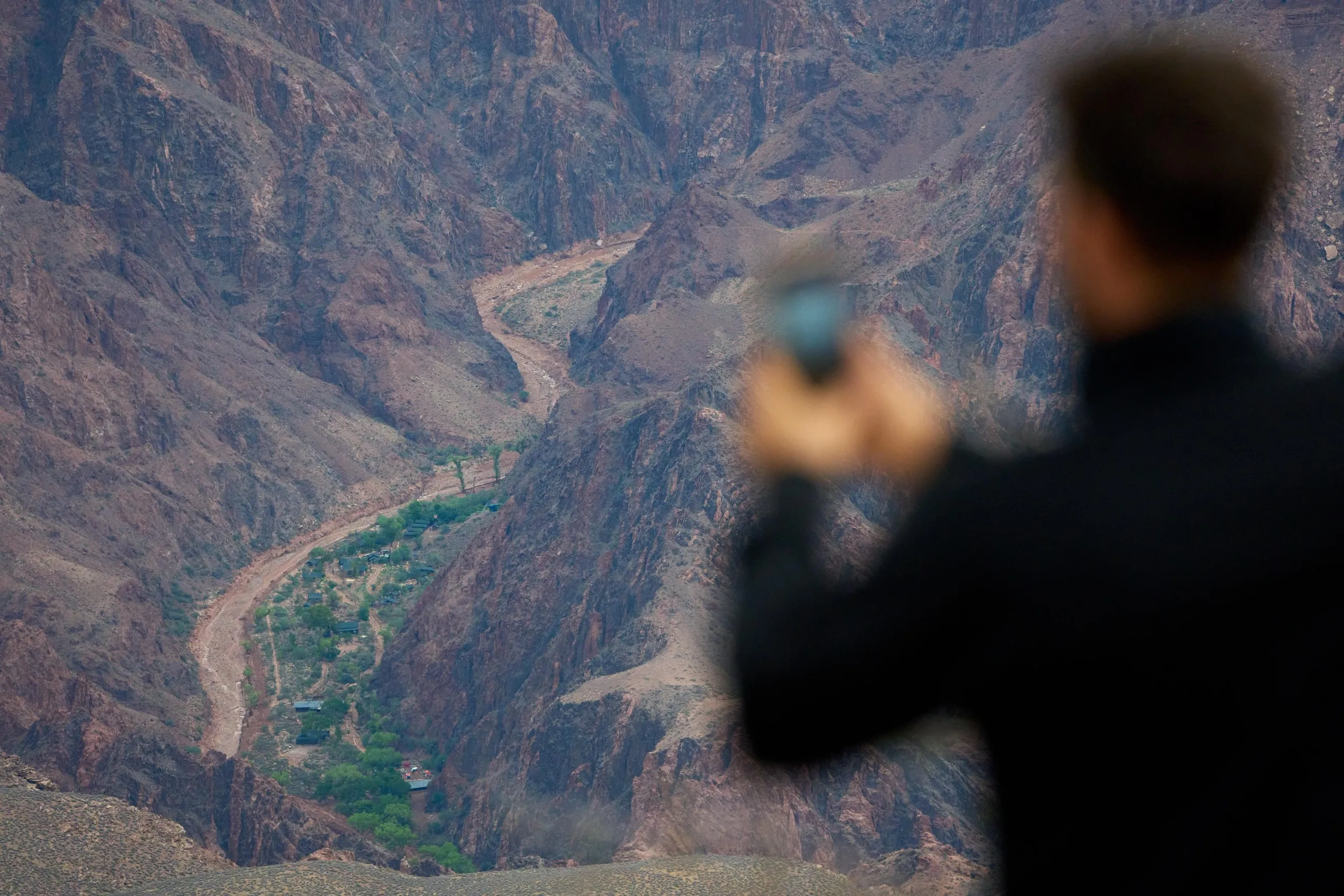 a person takes a picture of a flooded area in a canyon